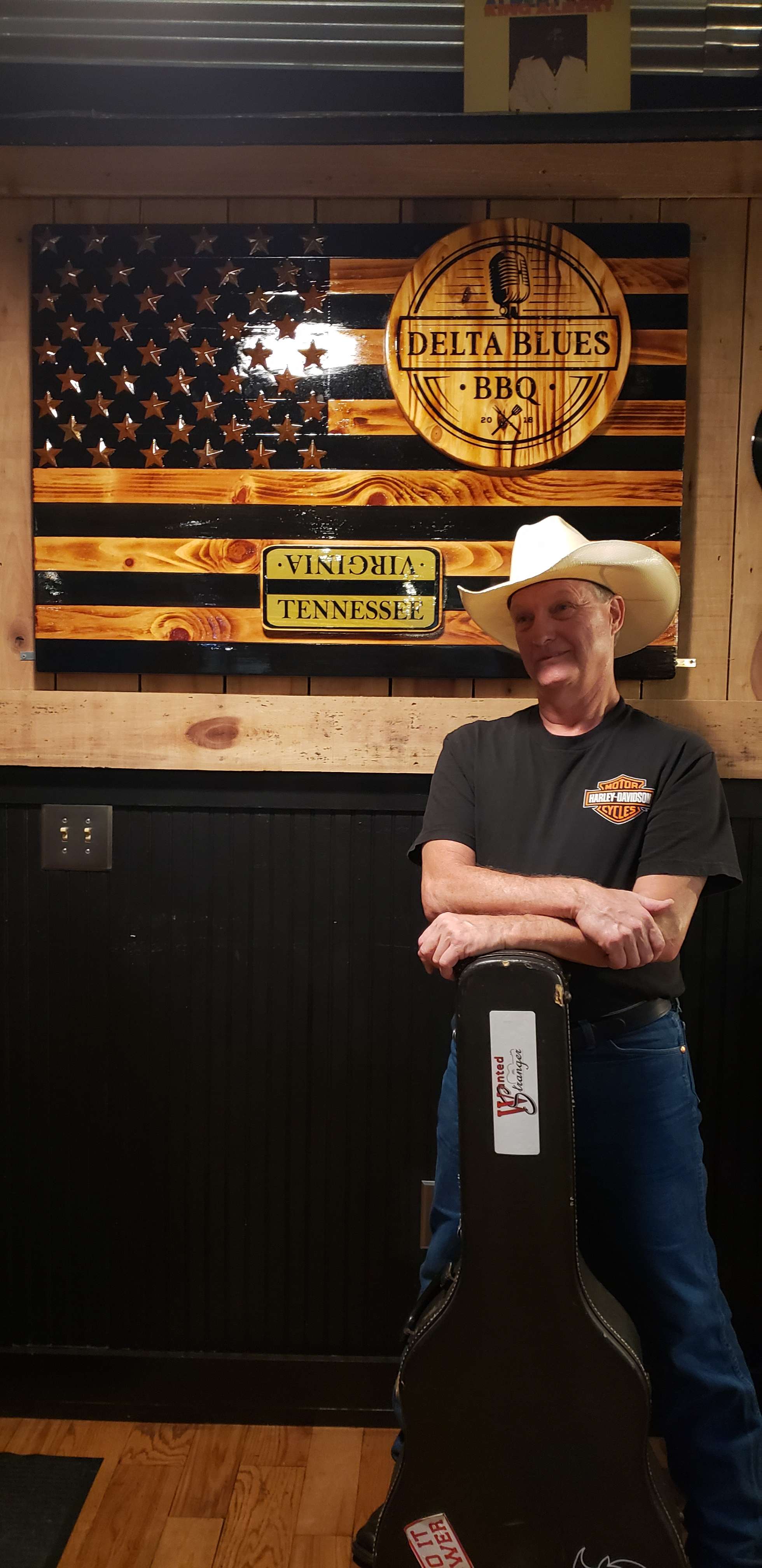 a man in a cowboy hat standing in front of an american flag