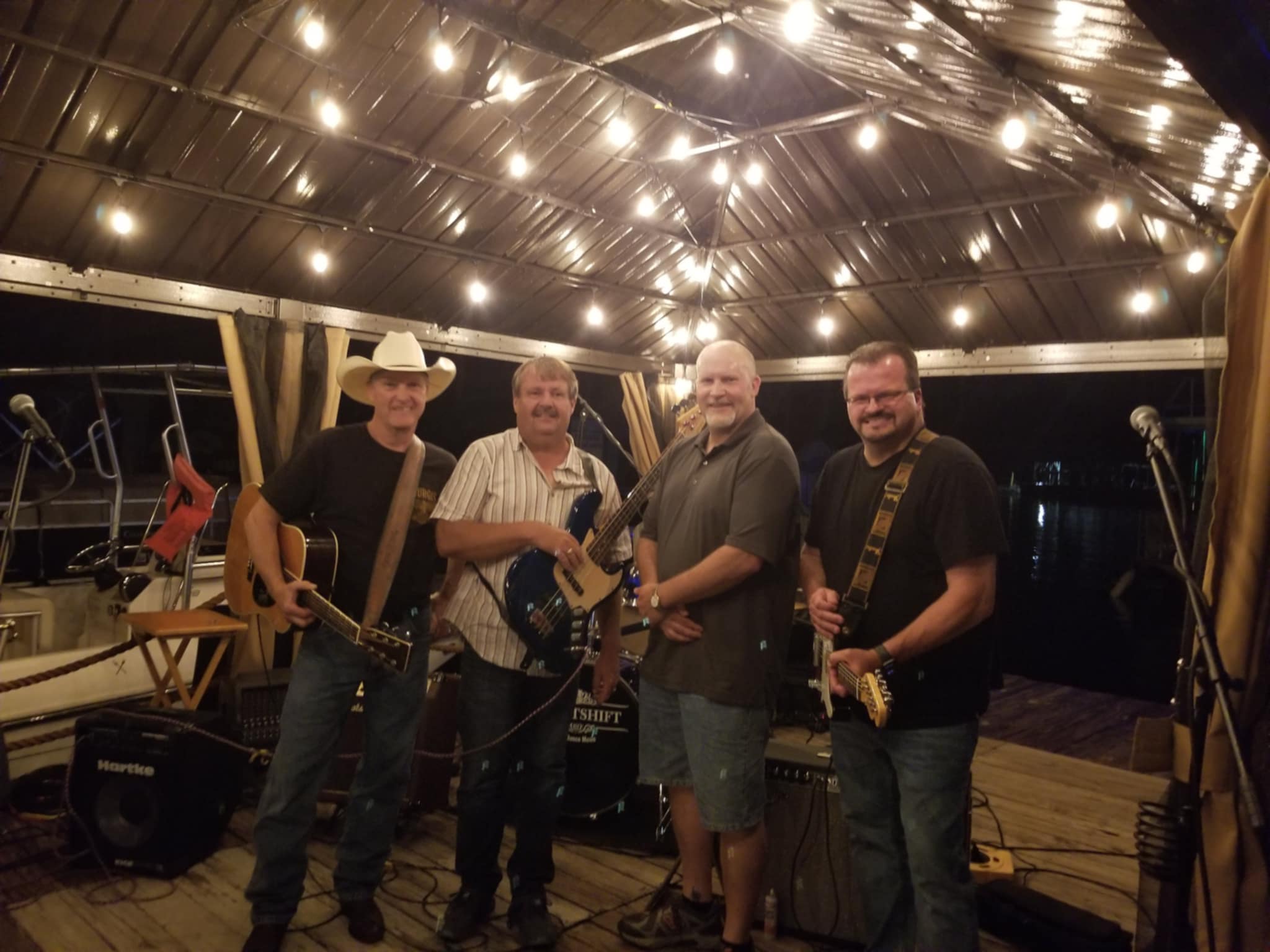 a group of men standing on a pier with guitars