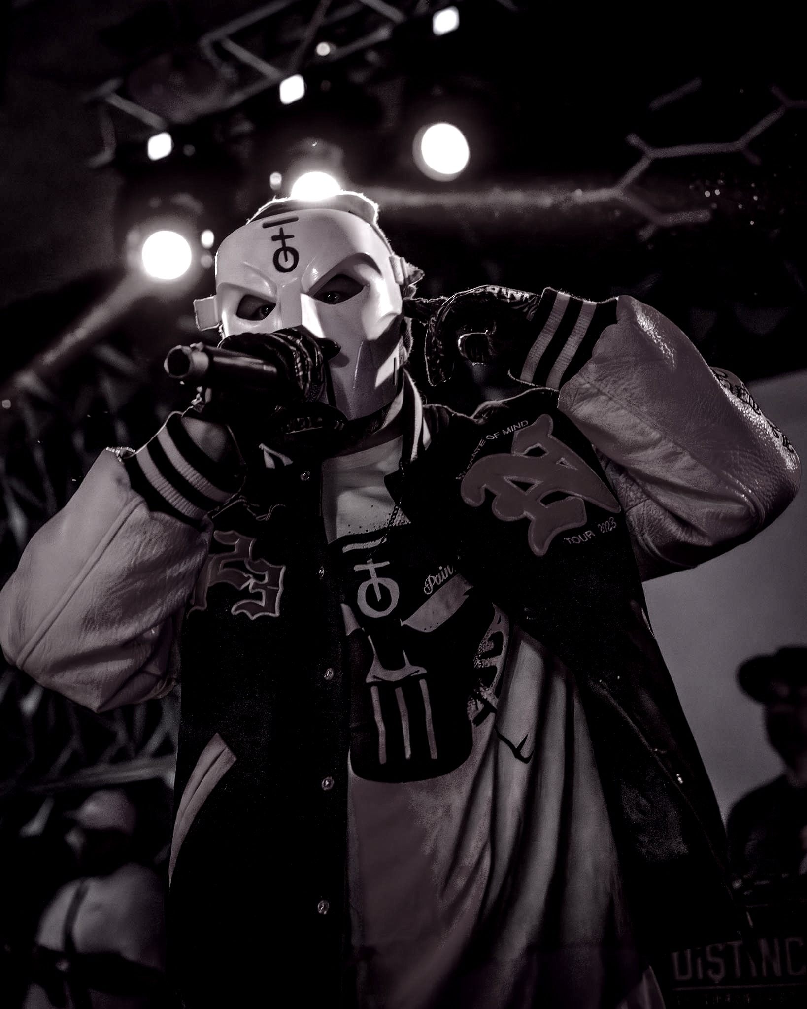 a man in a mask is holding a microphone