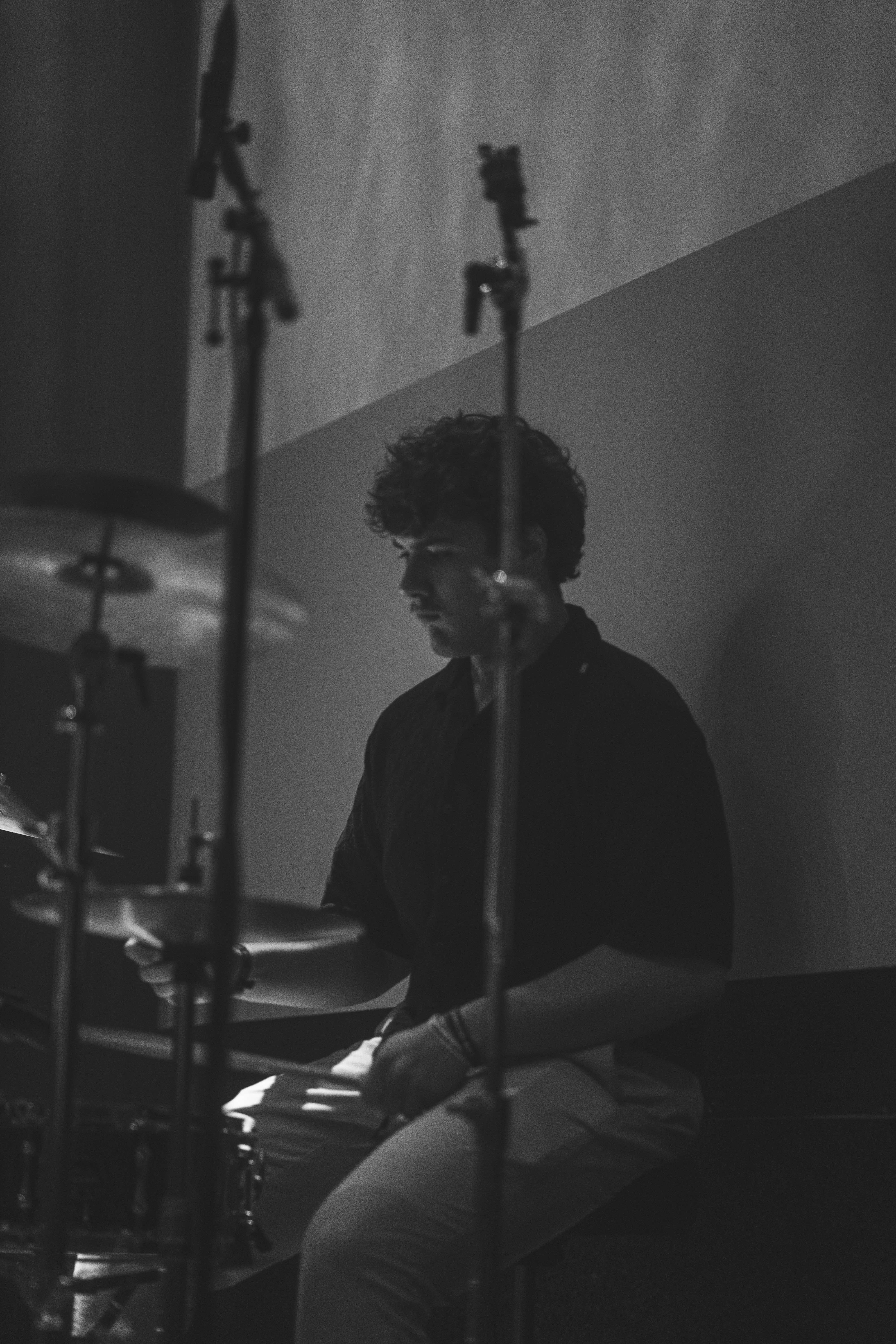 a black and white photo of a man playing drums