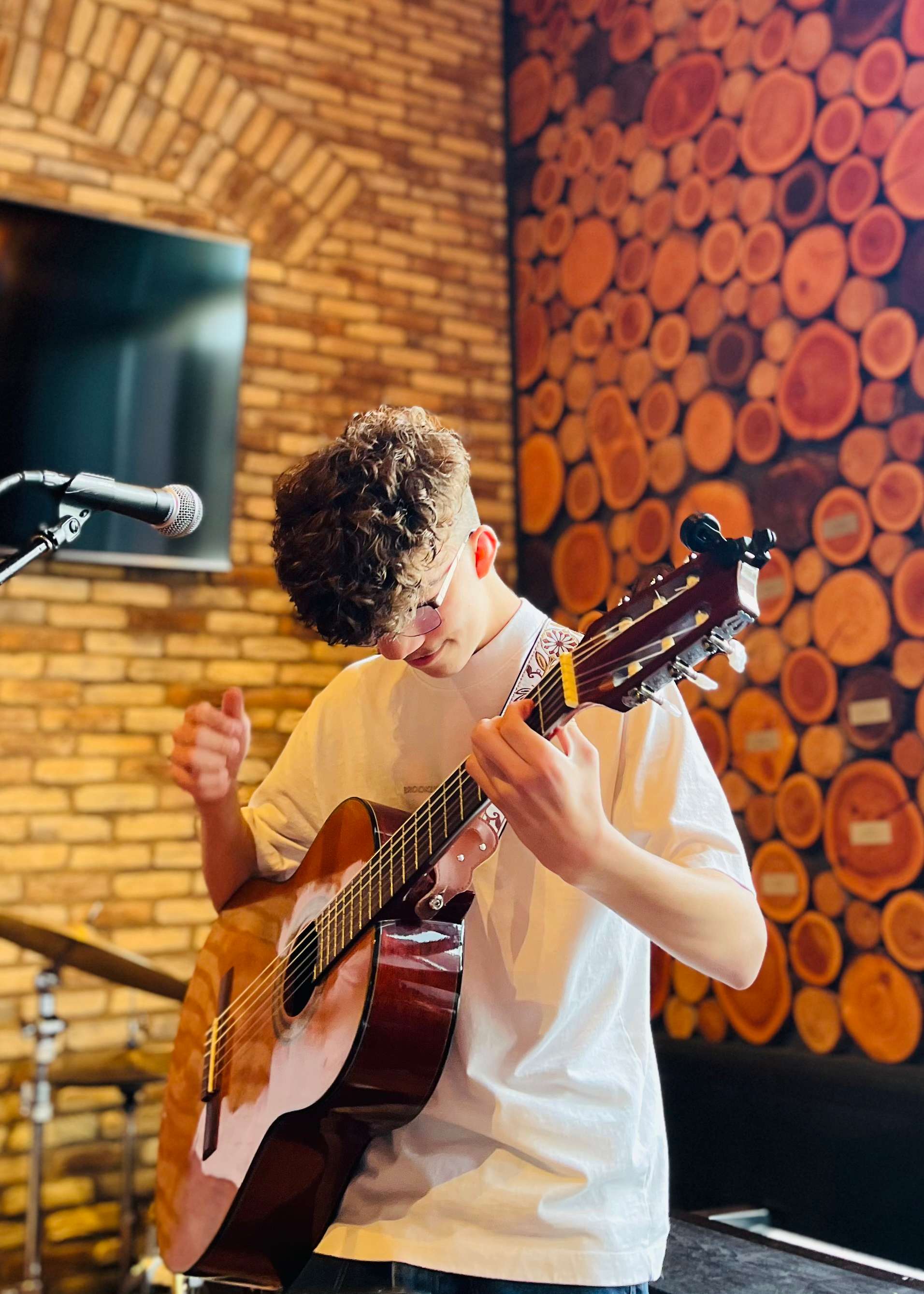 a young man playing an acoustic guitar in a bar