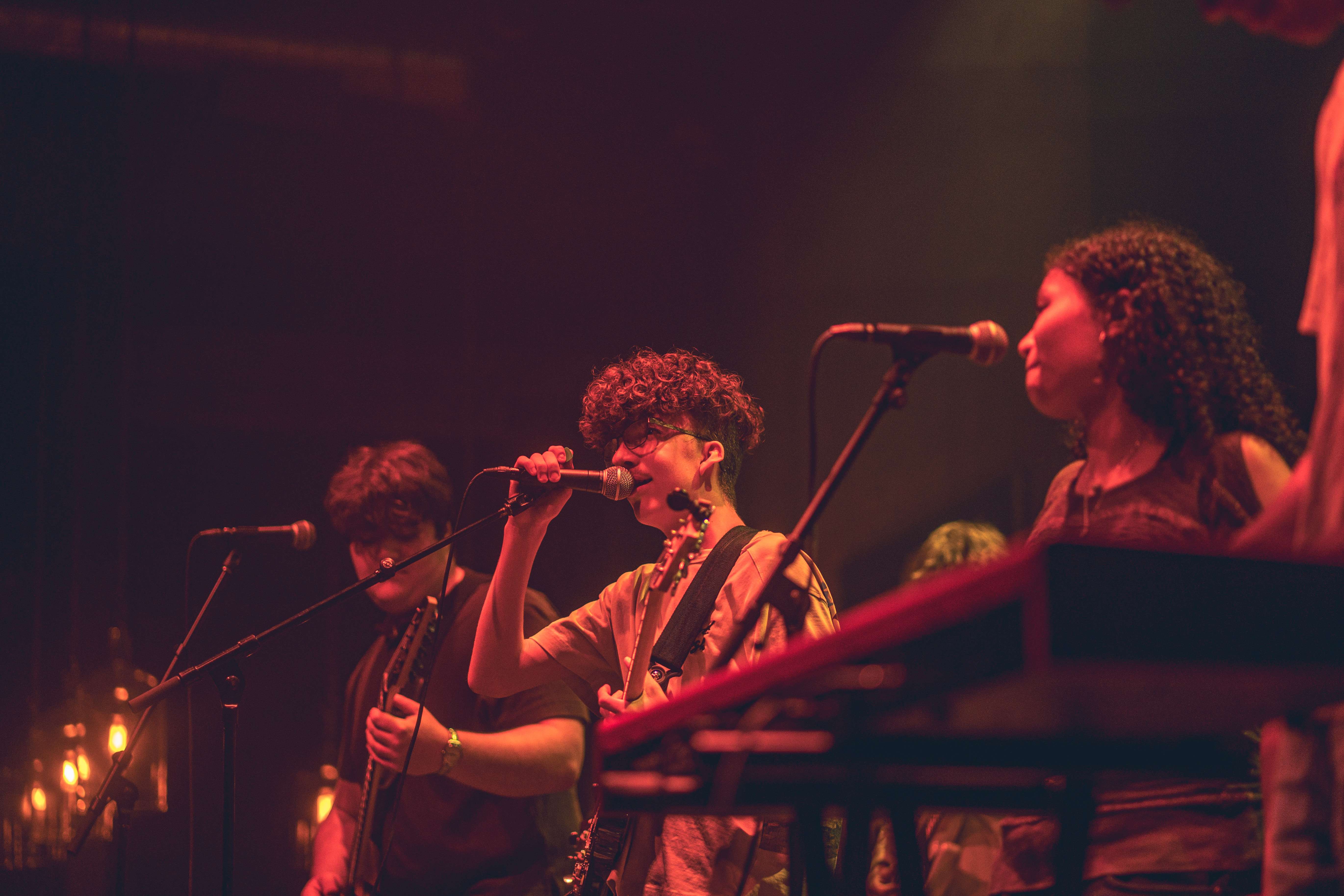 a group of people on stage with keyboards and microphones
