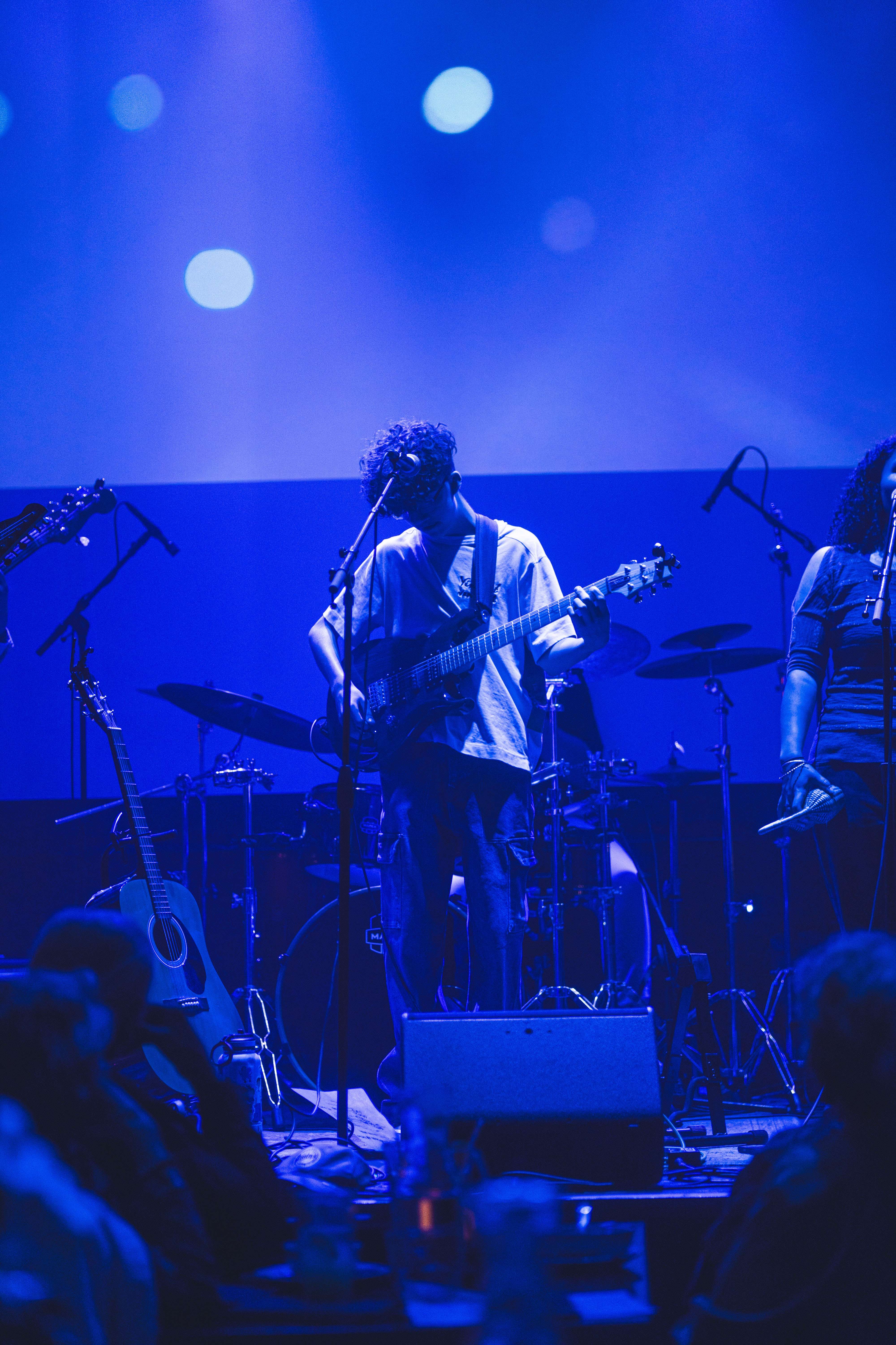 a group of musicians on stage in front of a blue light