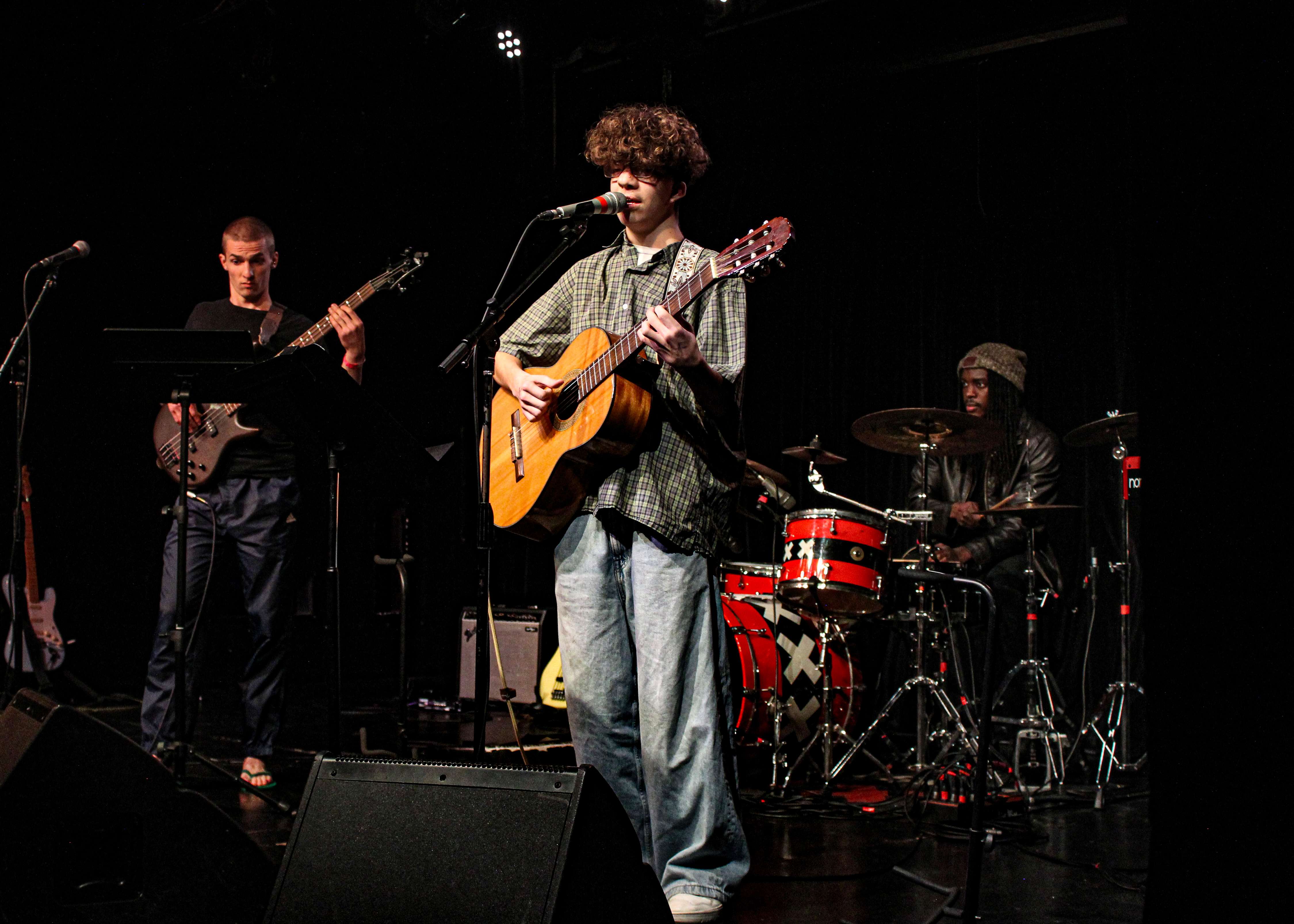 a man playing an acoustic guitar on stage