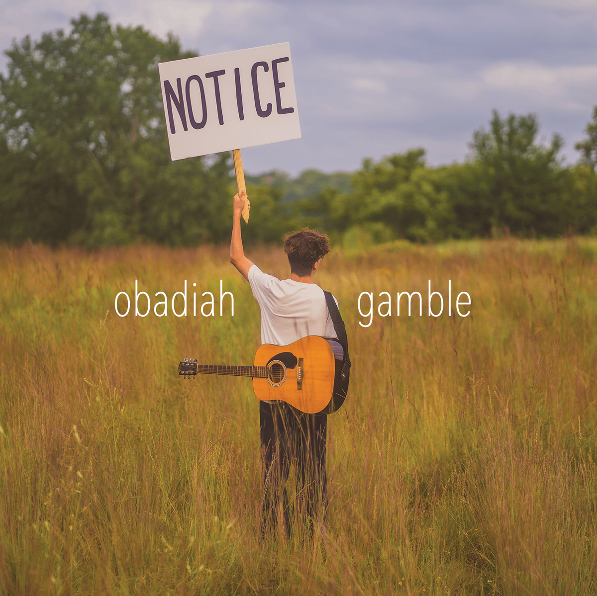 a man holding up a sign that says notice