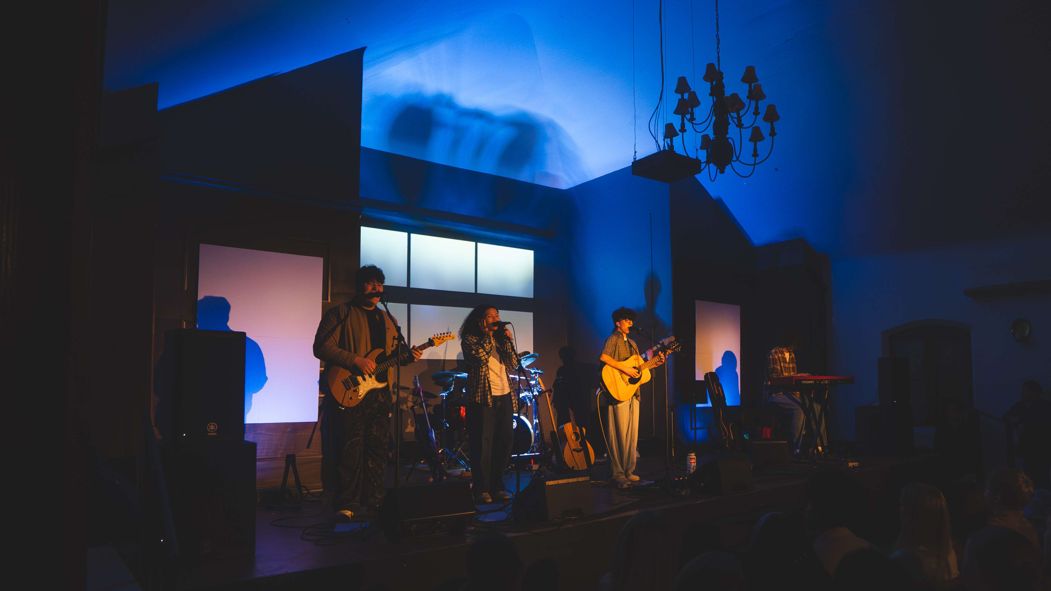 a band performs on stage in a dark room