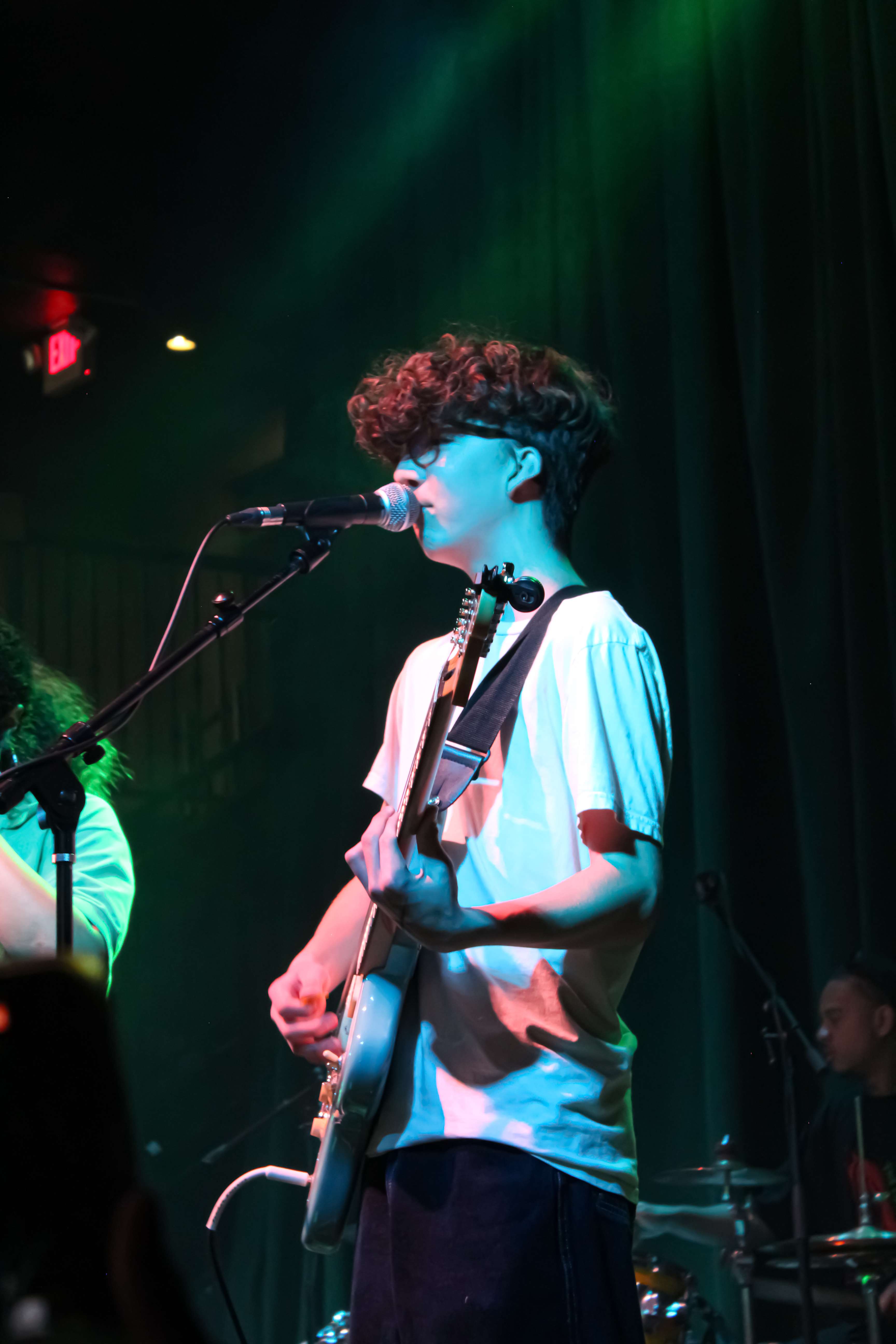 a group of people on stage with guitars and microphones