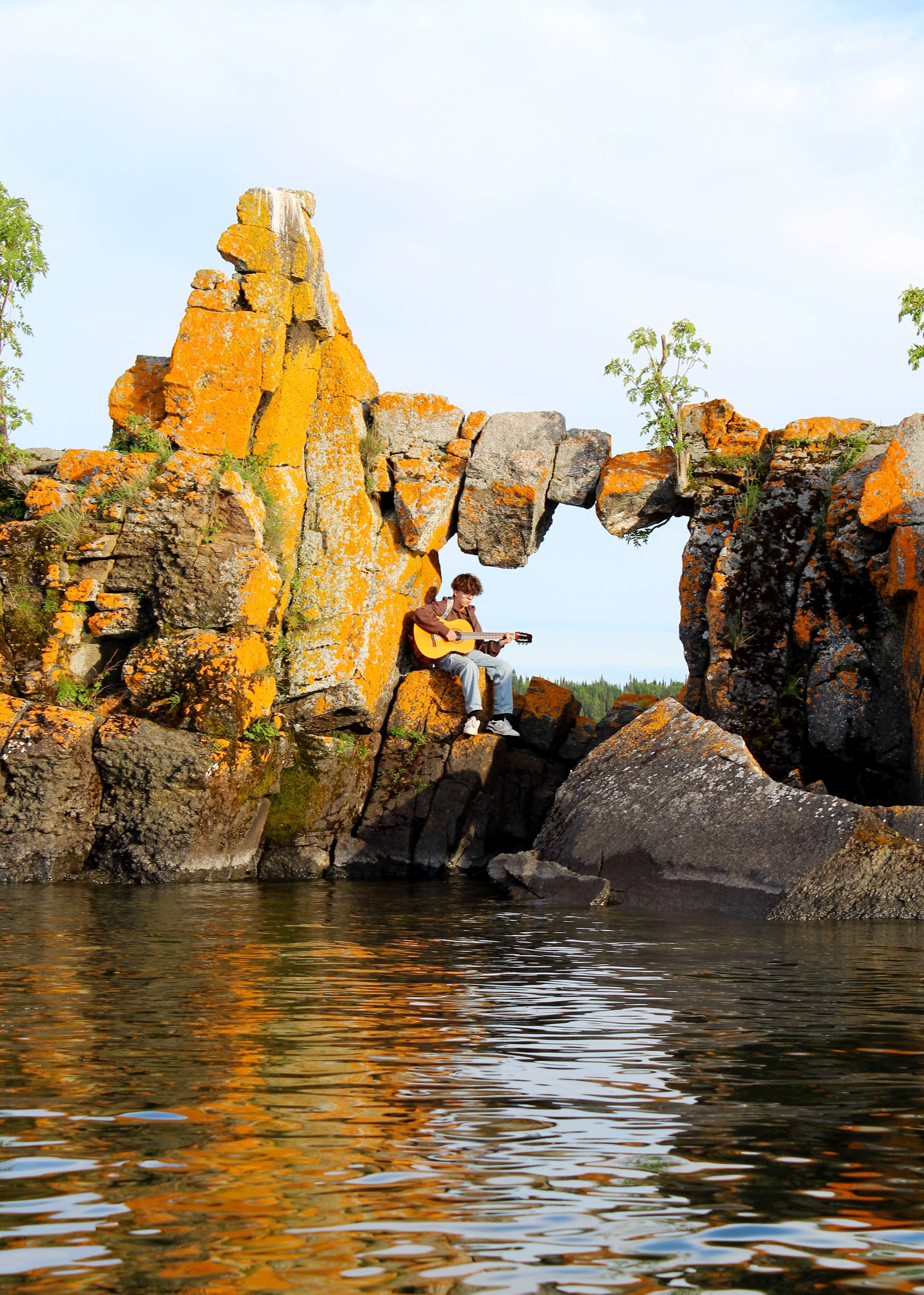 a man is sitting on a rock