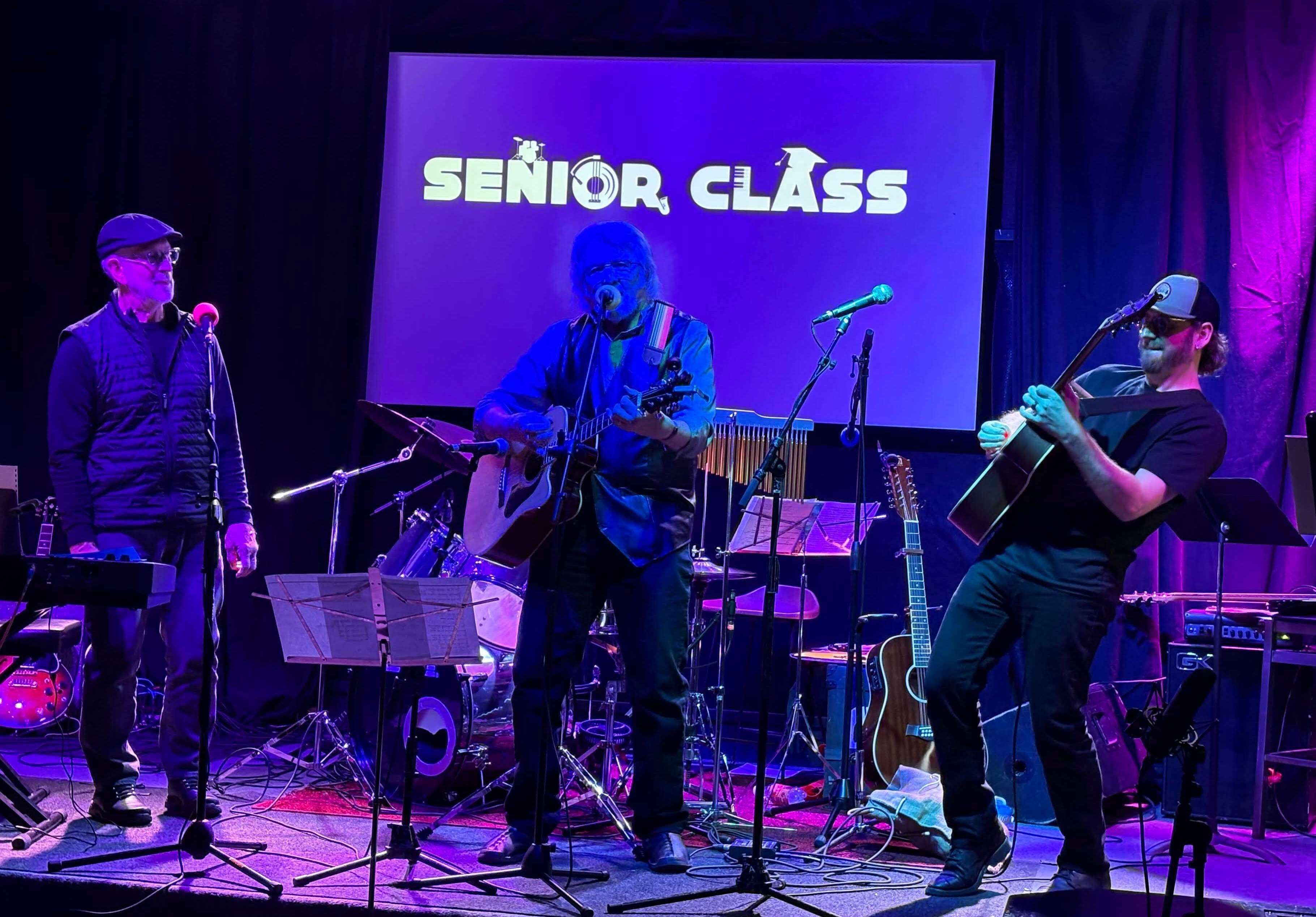 a group of musicians on stage with the word senior class