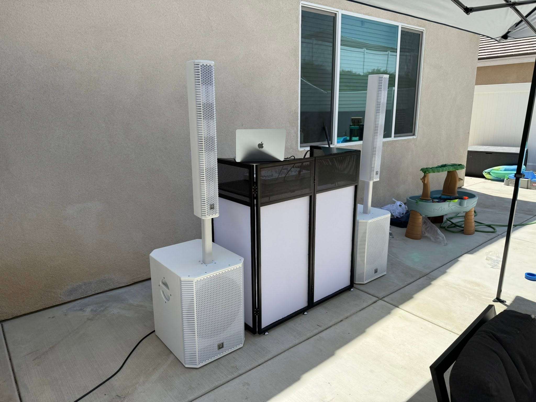 a dj set up in a backyard with speakers