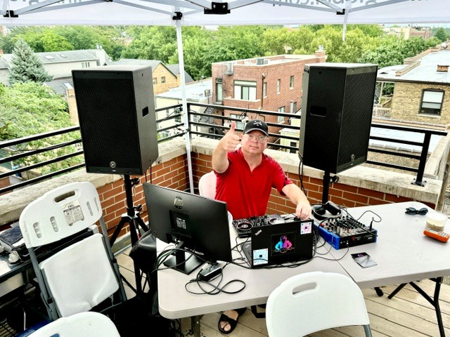 a man with a dj set up on a rooftop