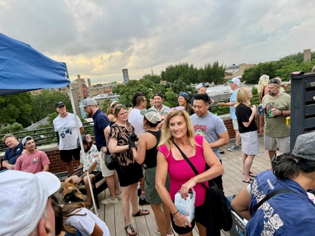 a crowd of people standing on a rooftop with umbrellas