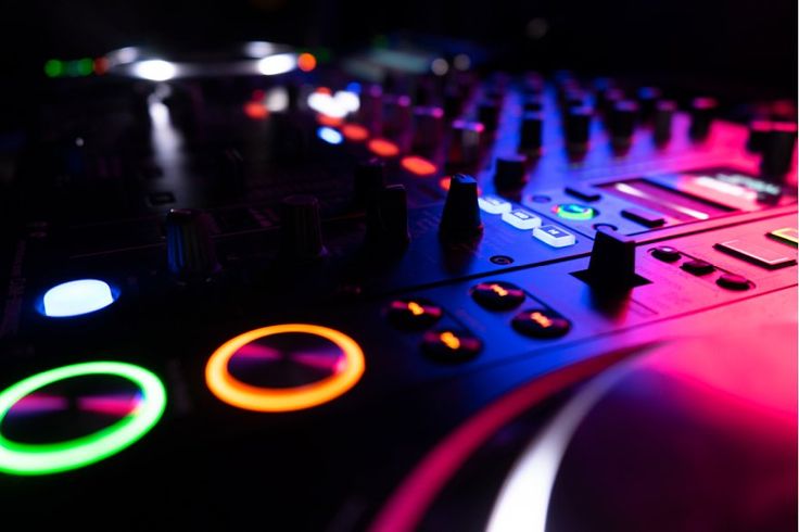 a close up of a dj mixer with colorful lights