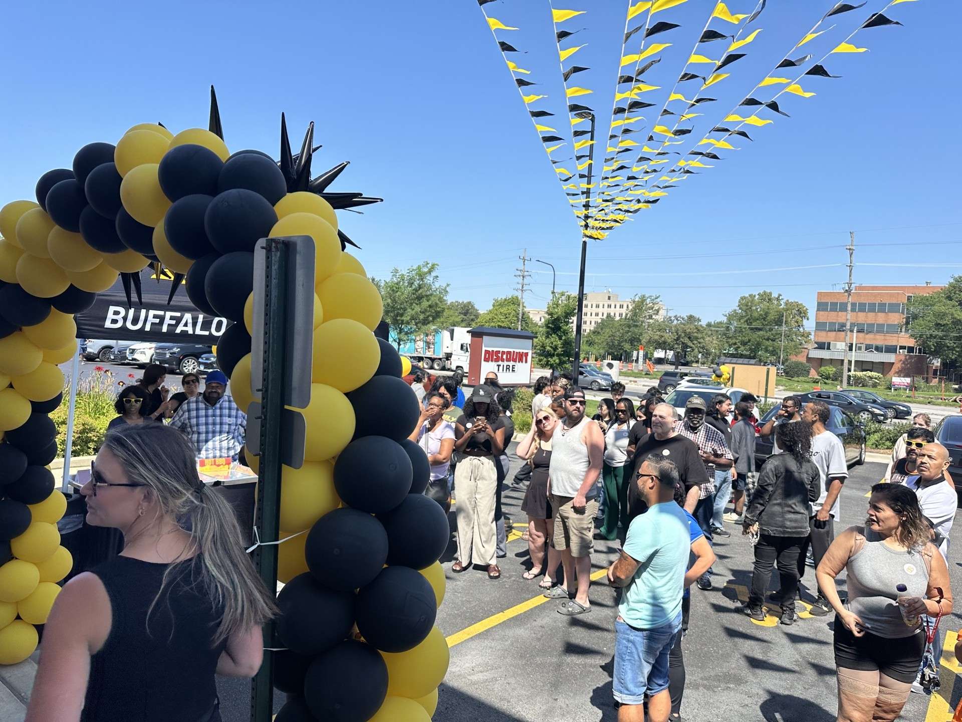 a crowd of people standing in front of a balloon arch