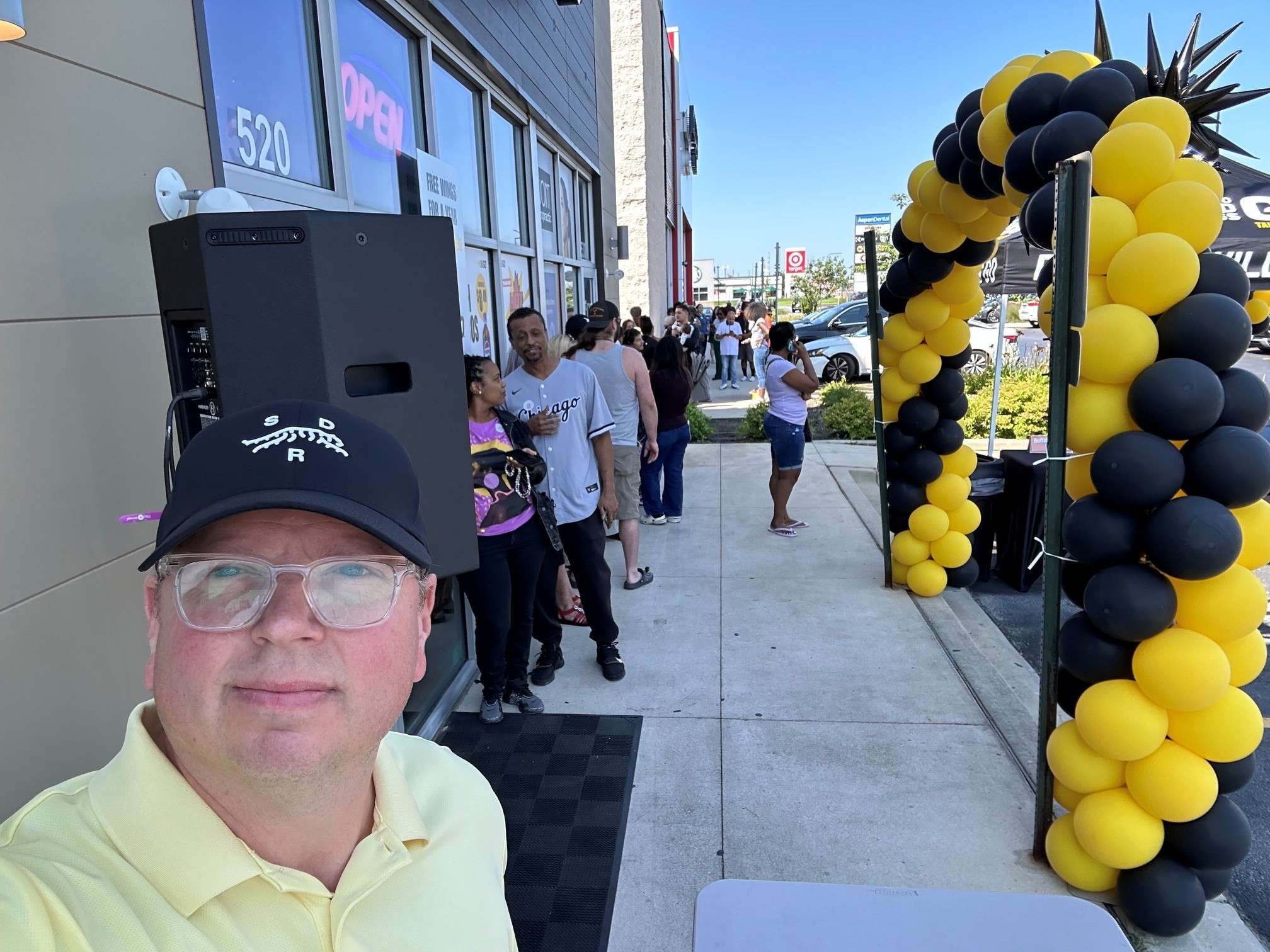 a man taking a selfie in front of a balloon arch