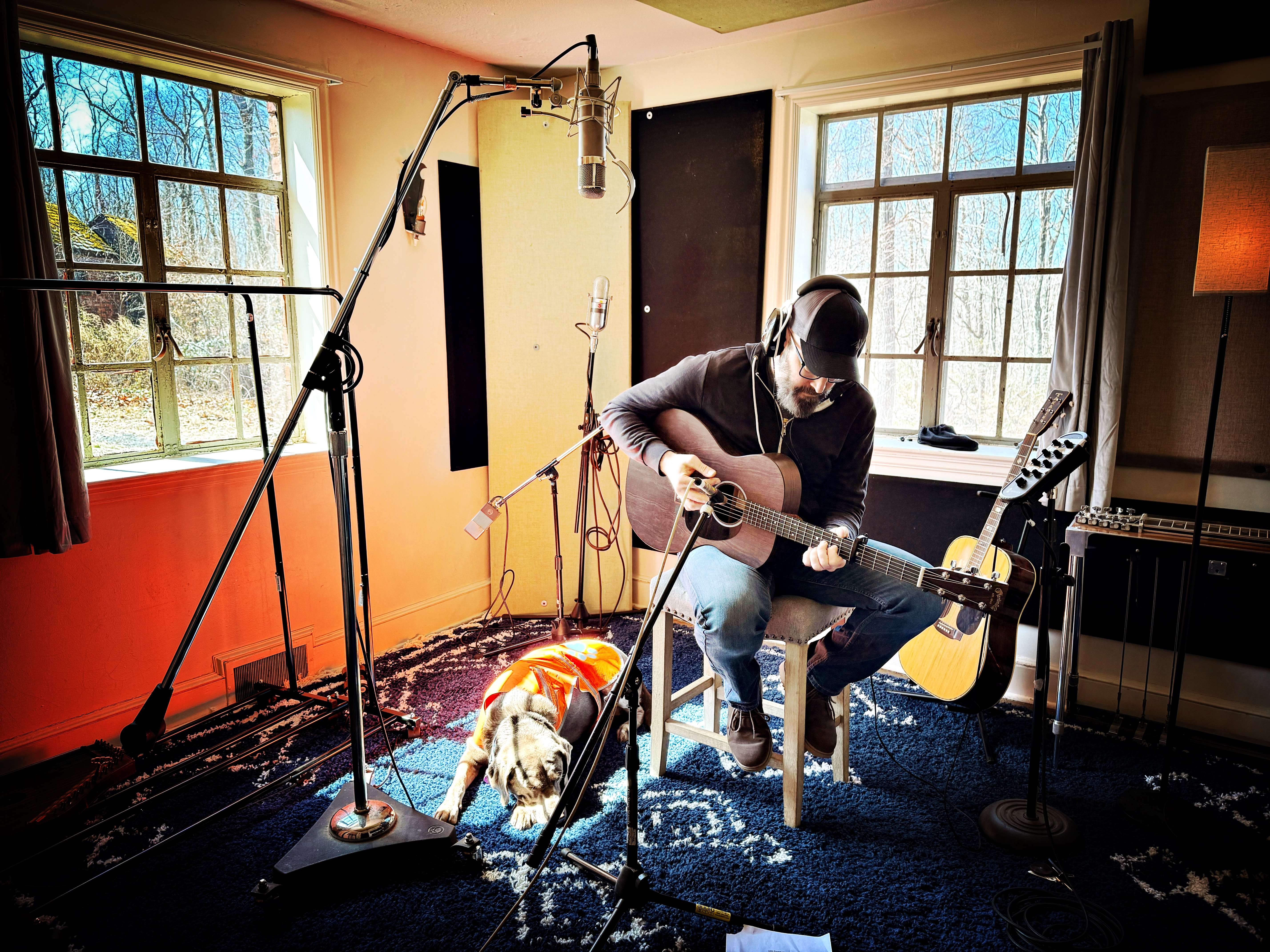 a man sitting in a chair with an acoustic guitar