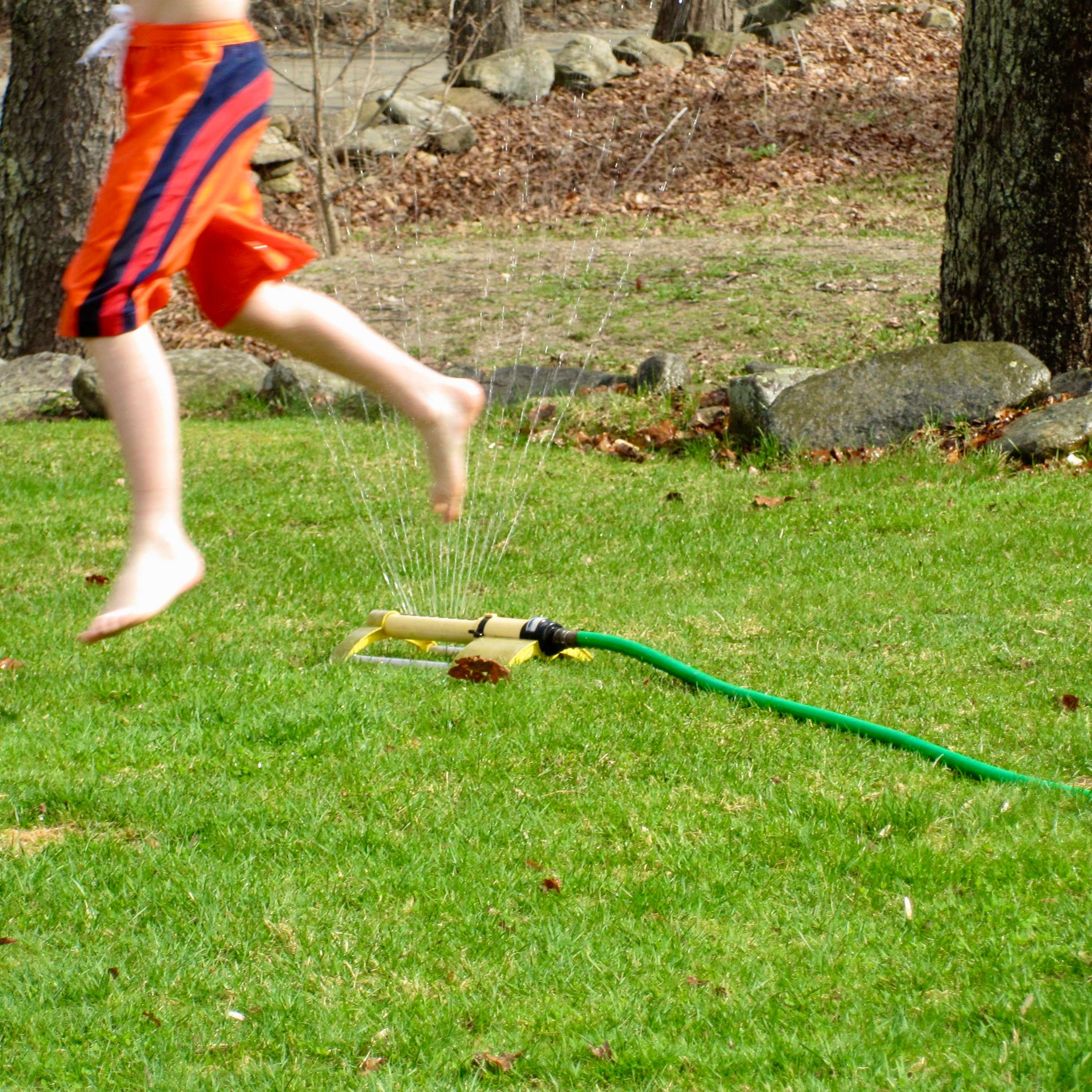 Yoder - Old House: a boy playing with a water hose and a frisbee