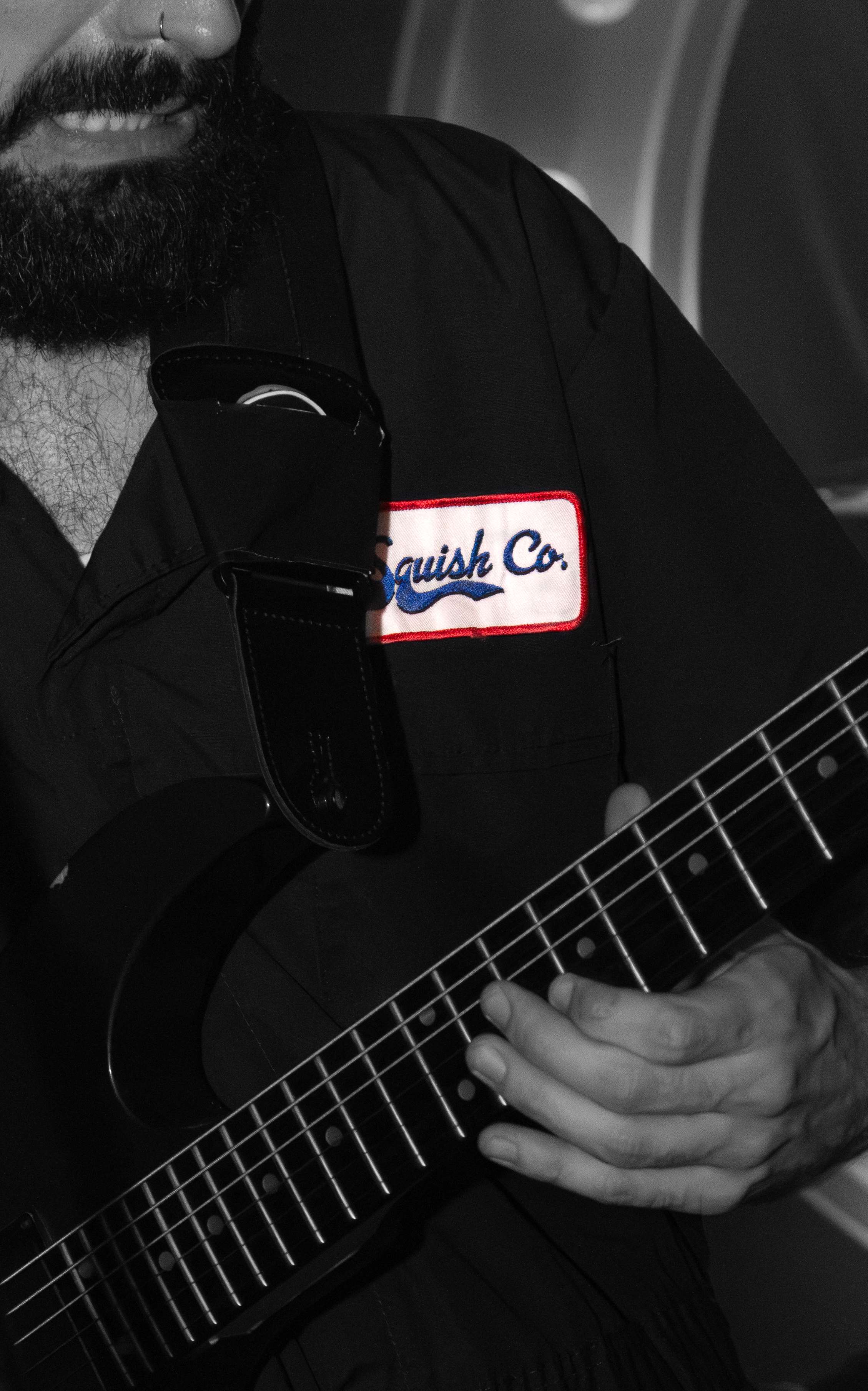 a man with a beard playing an electric guitar