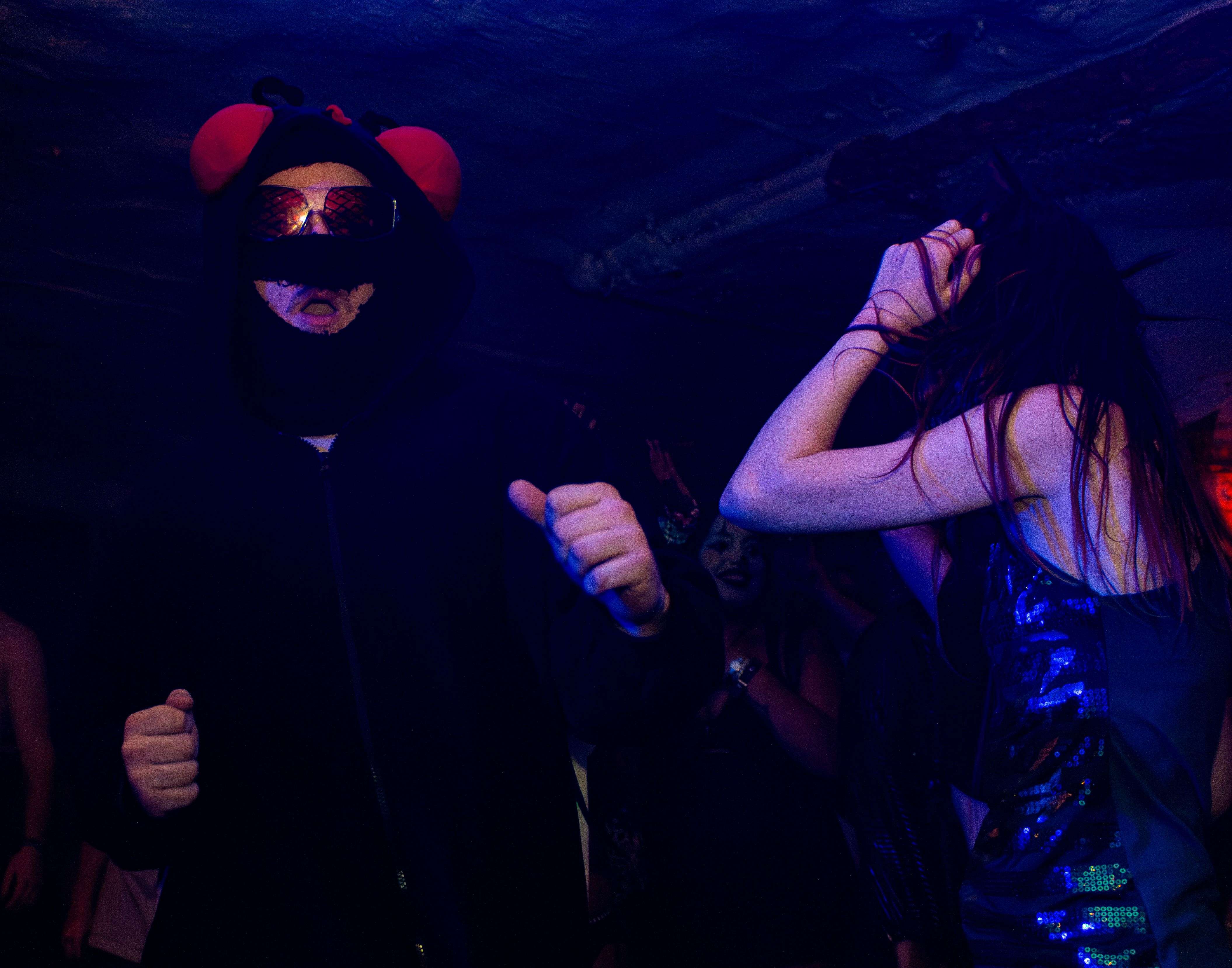 a woman dressed as a devil is dancing at a party