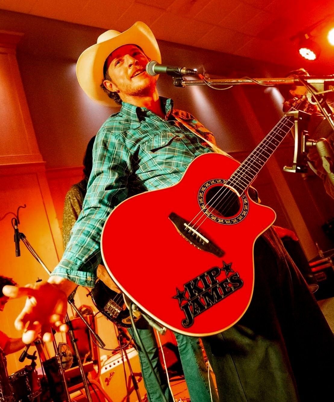 a man in a cowboy hat playing an acoustic guitar