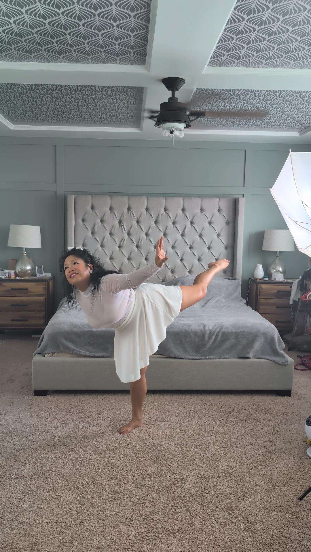 a woman doing a yoga pose in a bedroom