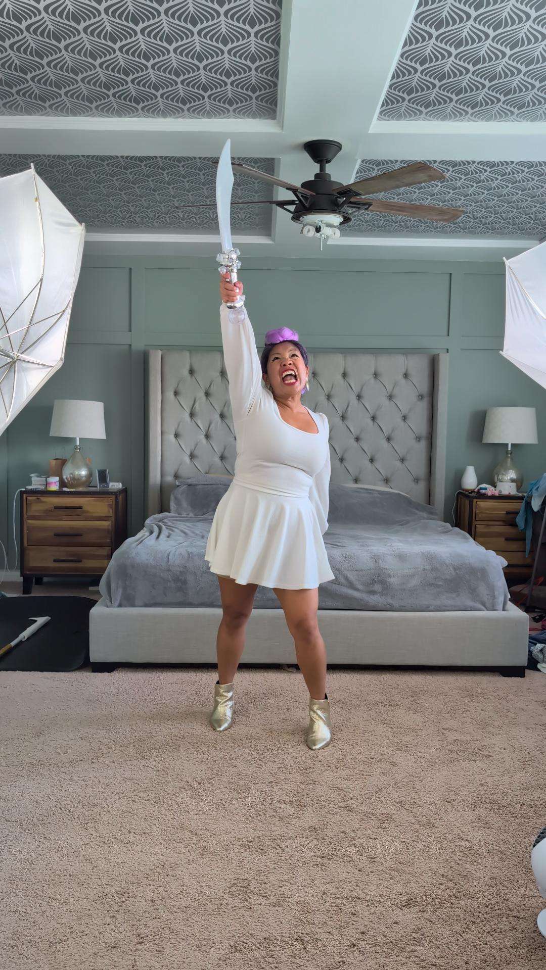 a woman in a white dress standing in a bedroom