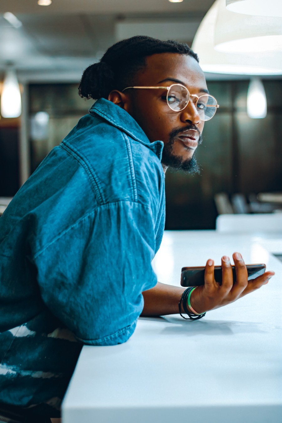 a man wearing glasses and a denim jacket