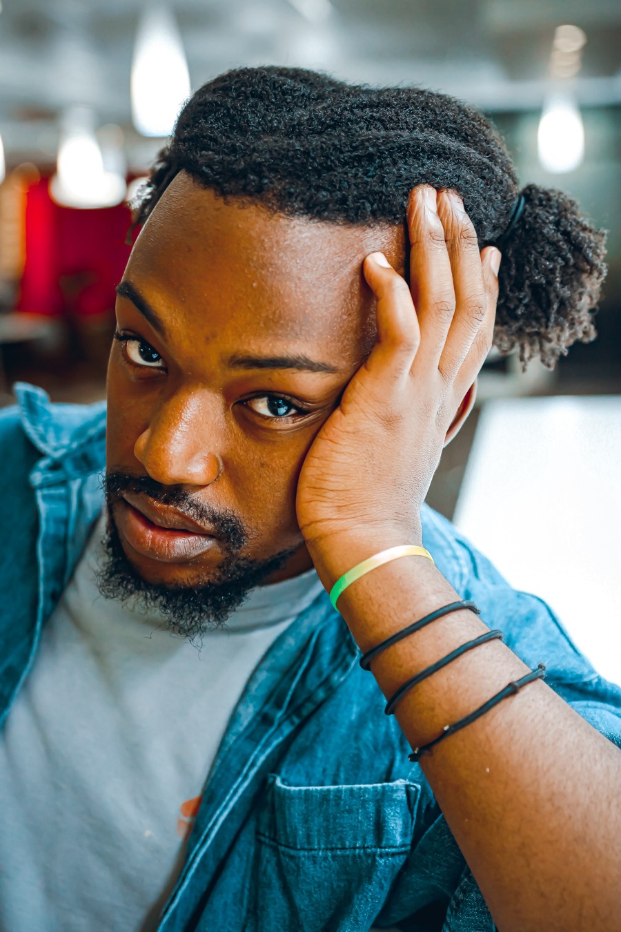 a black man with dreadlocks looking at his hand