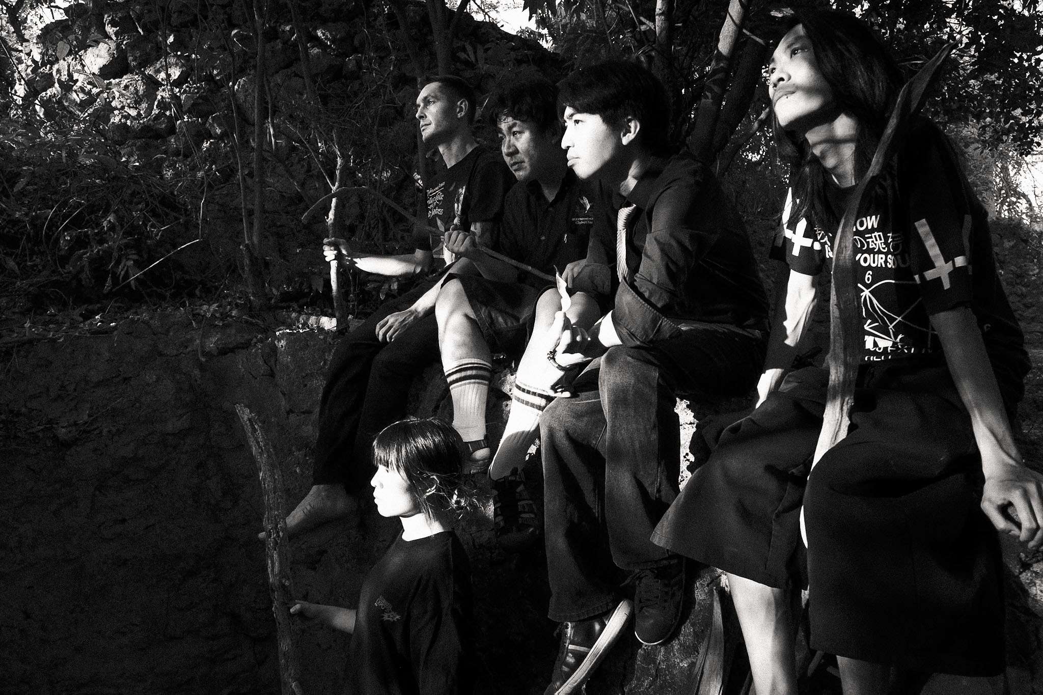 black and white photo of a group of people sitting on a rock