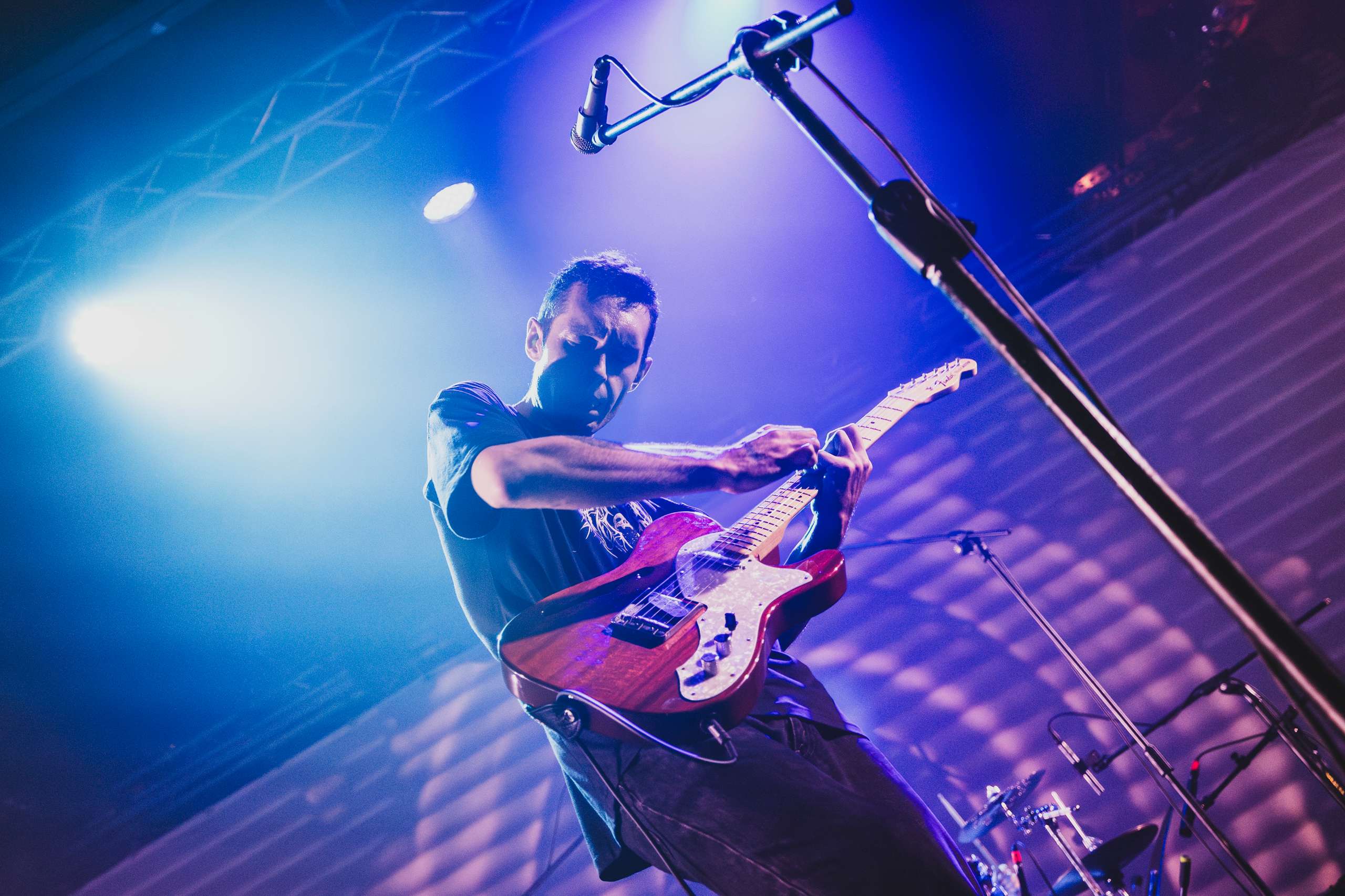 a man playing an electric guitar on stage