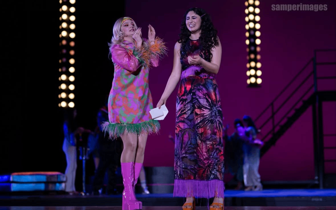 two women in colorful dresses on stage