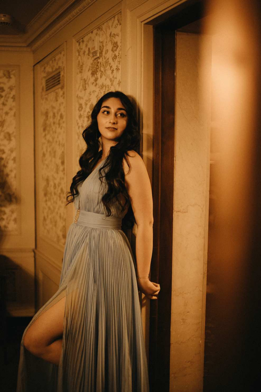 a woman in a blue dress posing in a room
