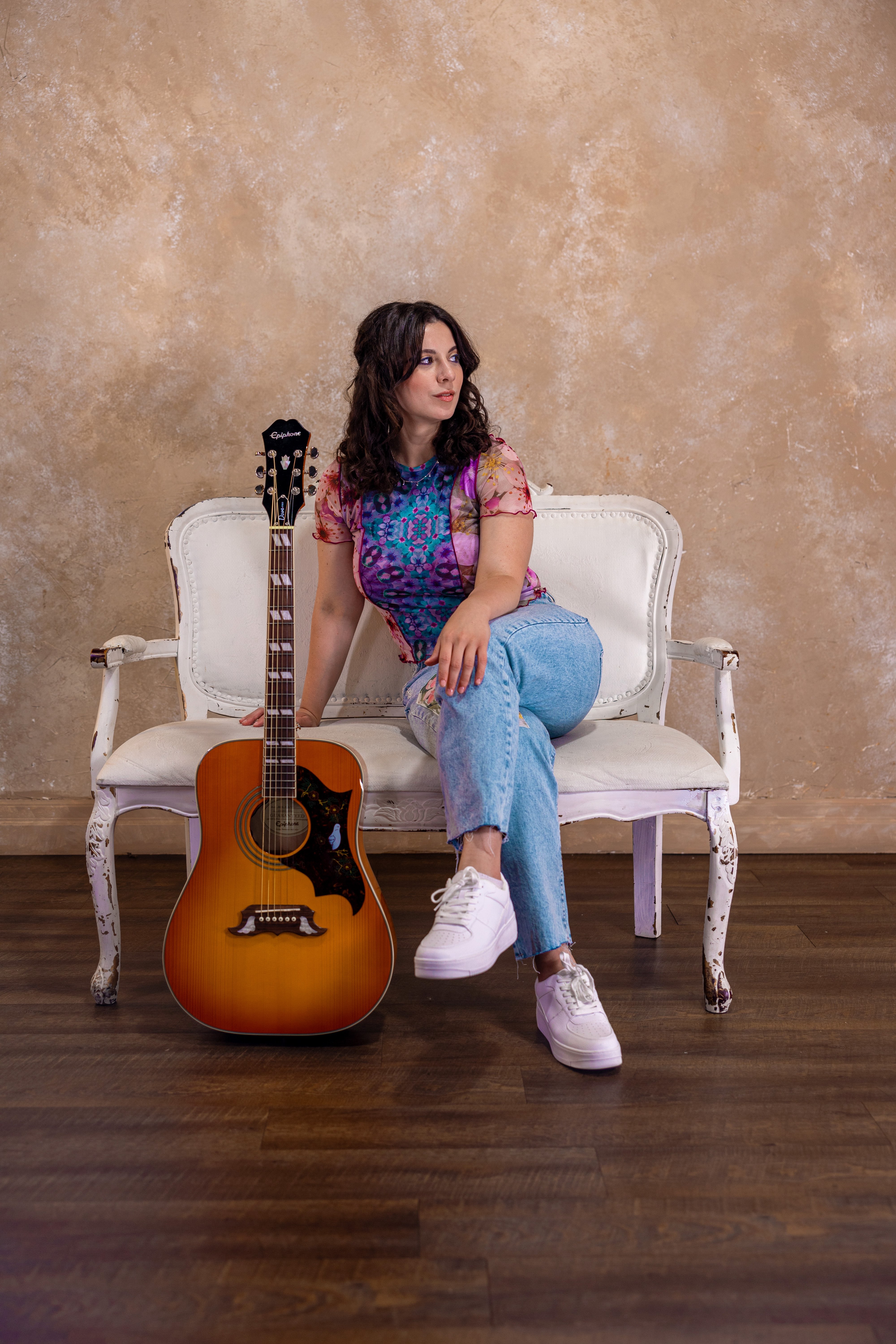 a woman sitting on a chair with an acoustic guitar