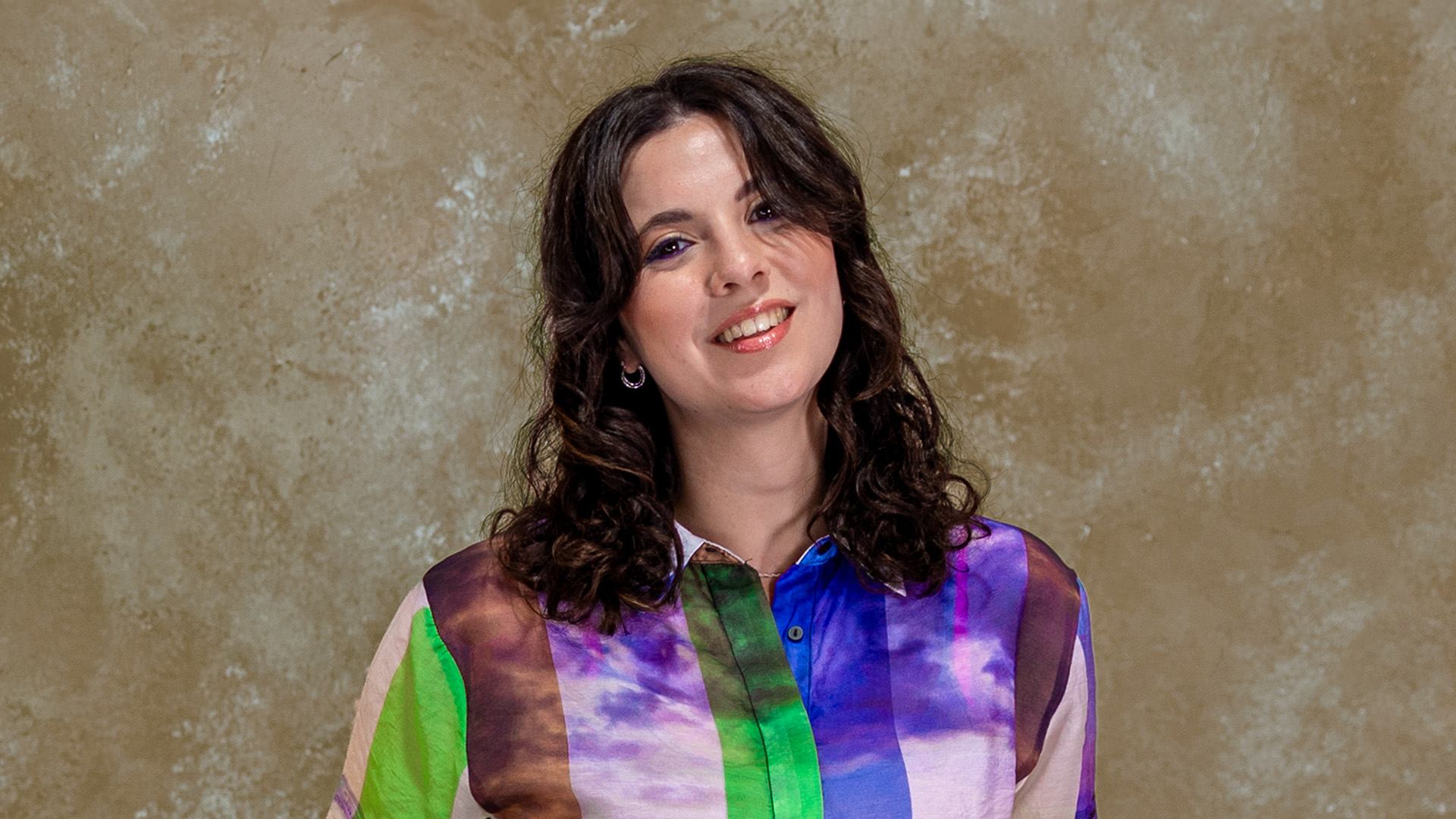 a woman in a colorful shirt posing for a photo