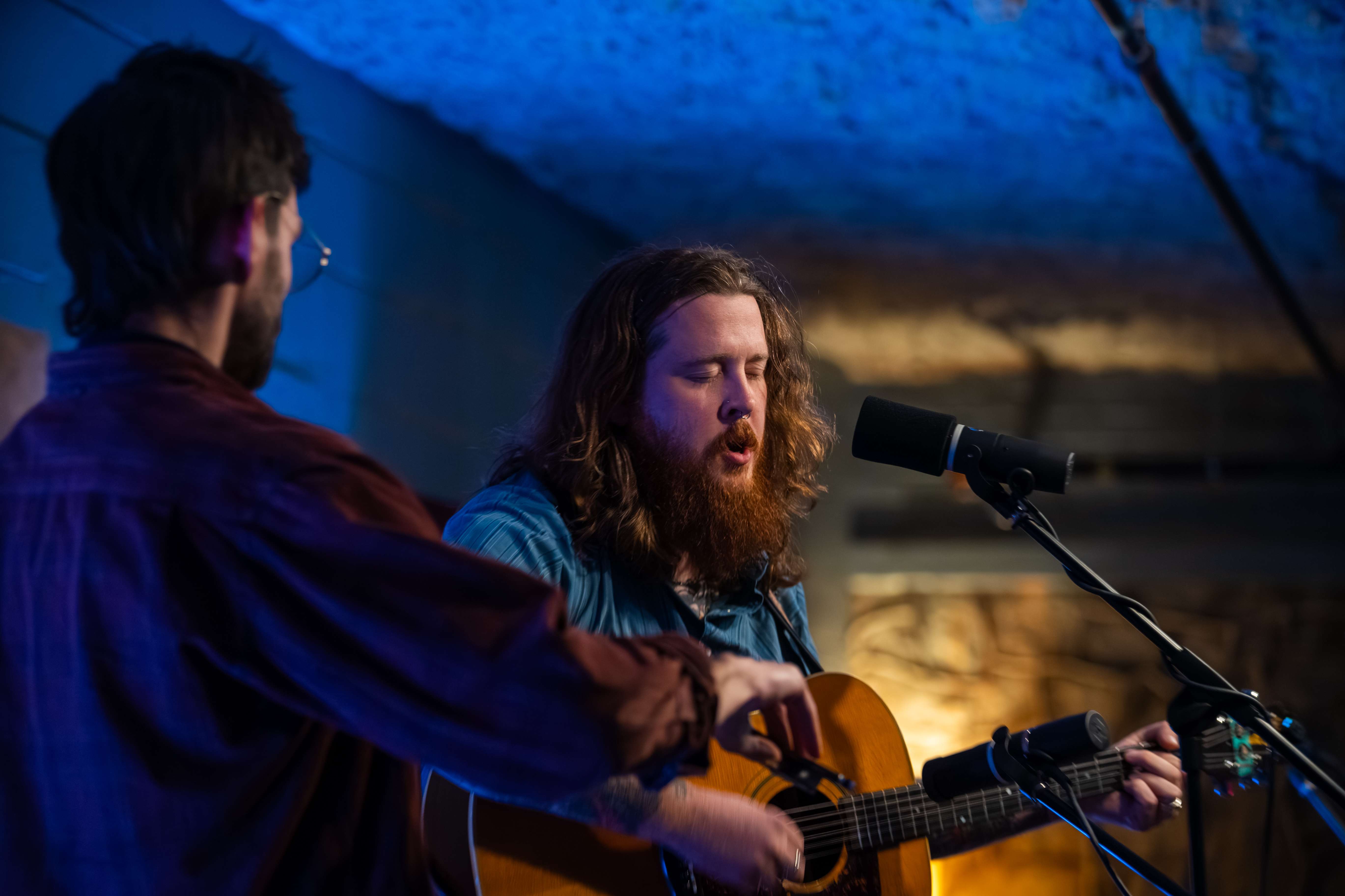 two men with long beards singing into microphones