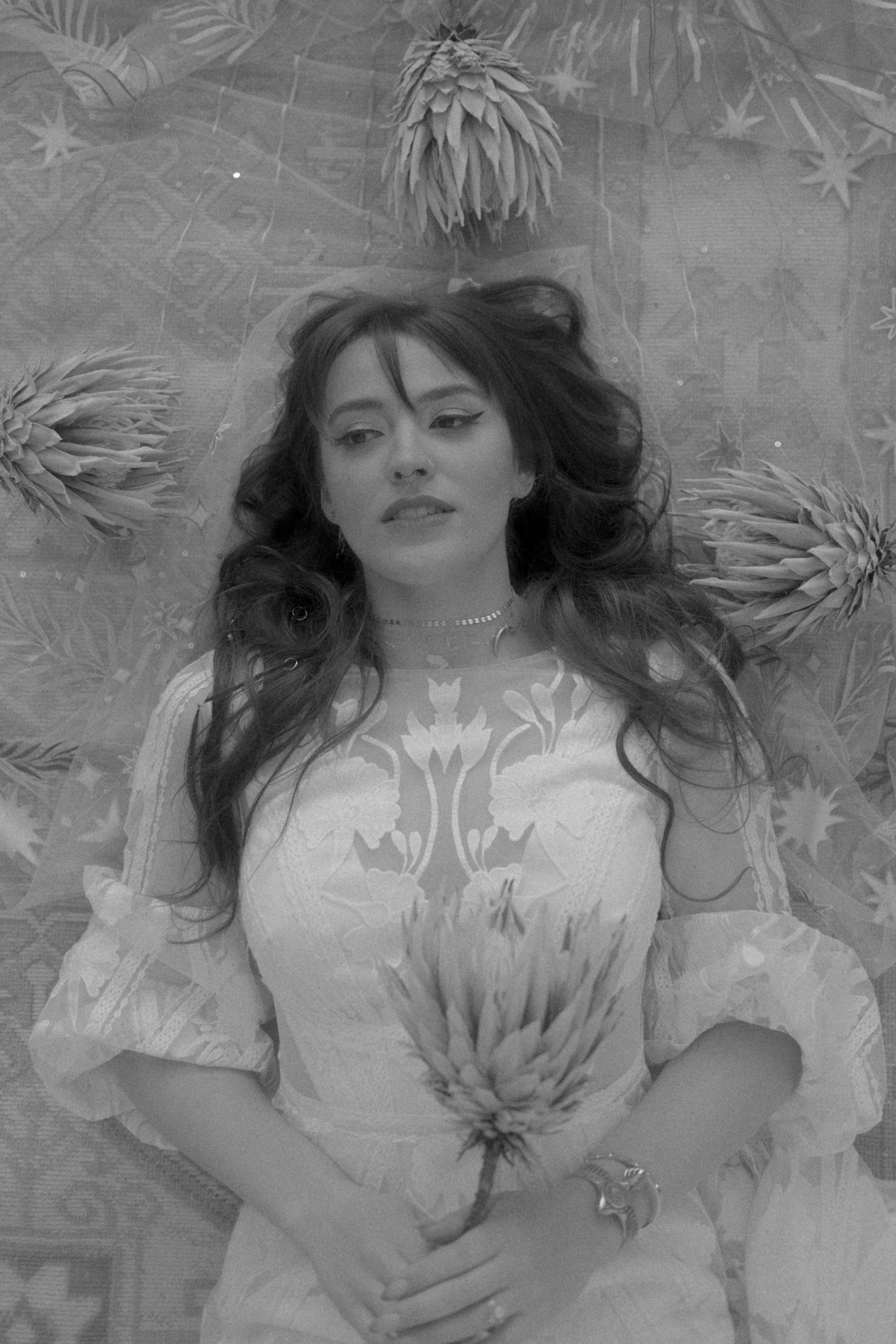 Mackenzie Morrow tip jar: a black and white photo of a woman laying on a bed with flowers