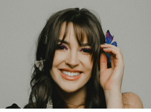 a woman smiling with a butterfly in her hair