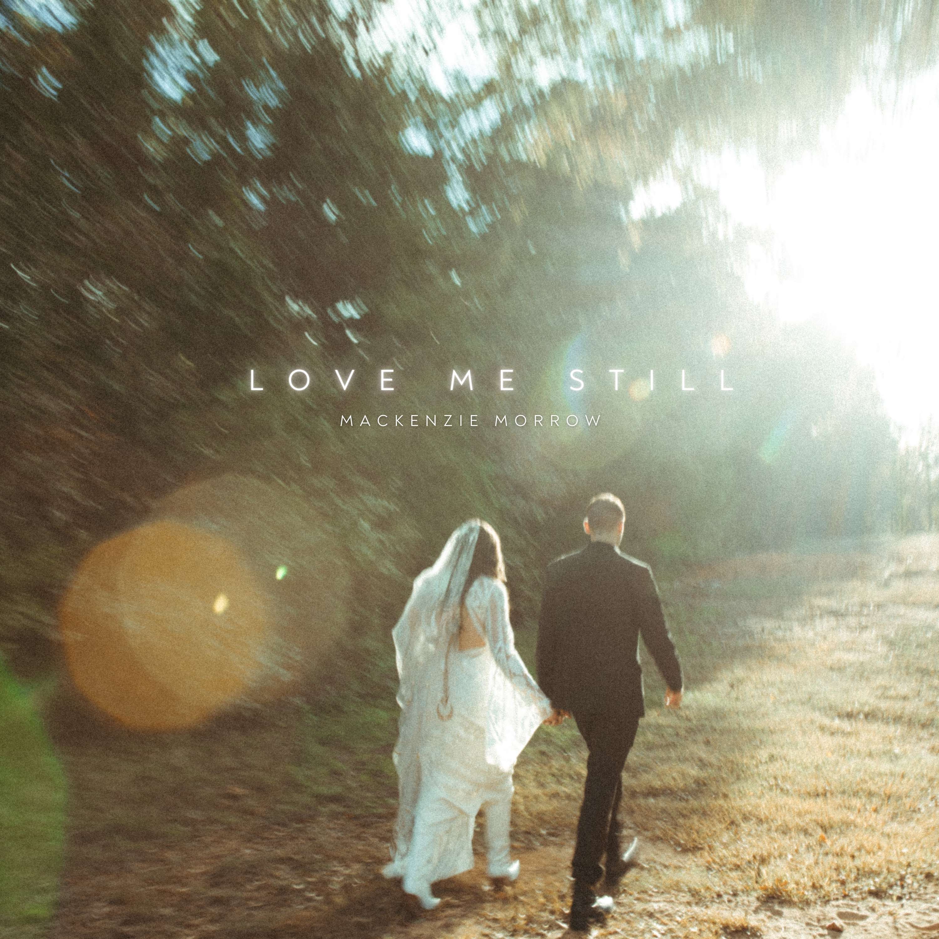 Mackenzie Morrow - Love Me Still: a bride and groom walking down a path with the words love me still