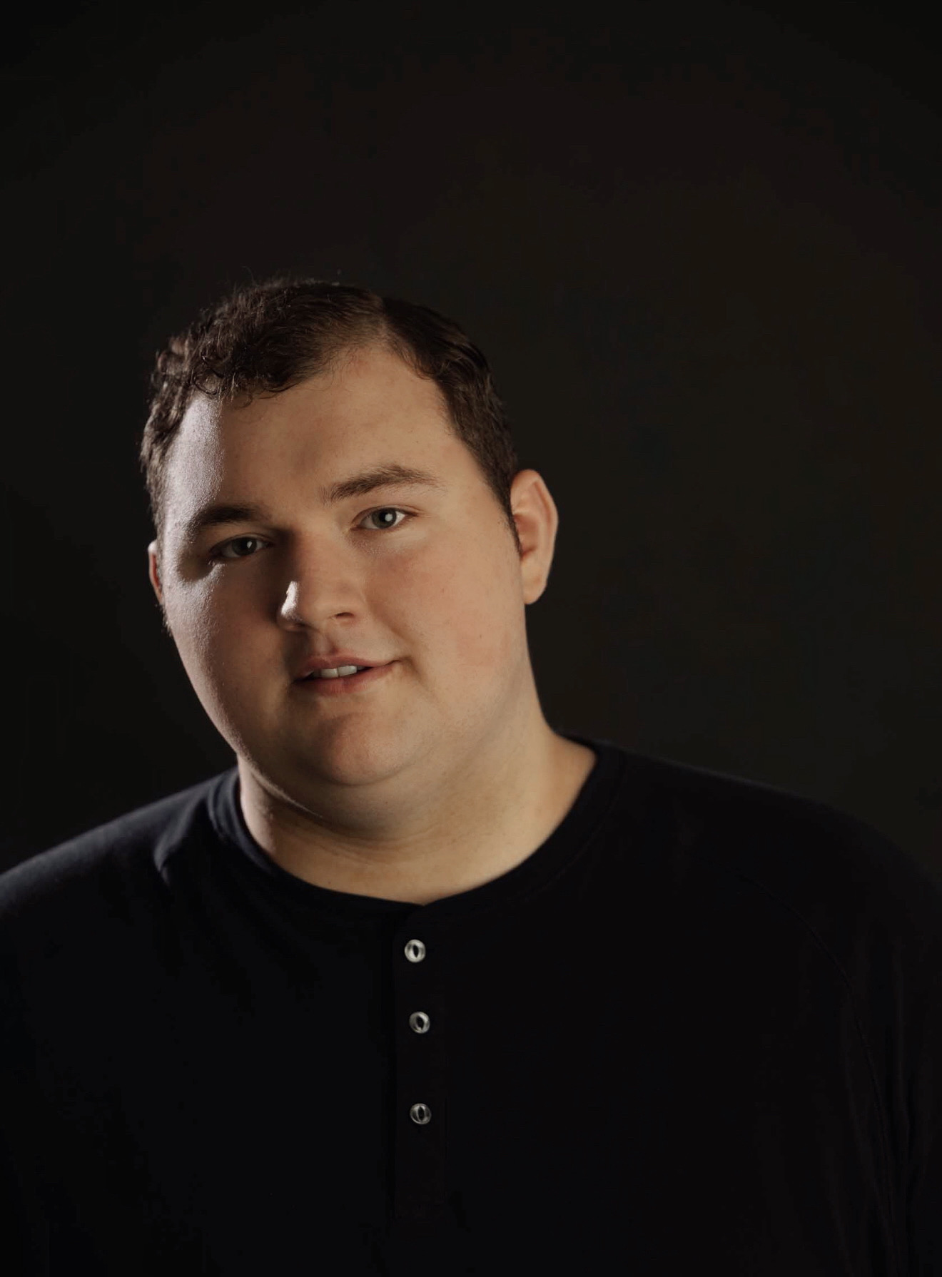 a man in a black shirt is posing for a photo