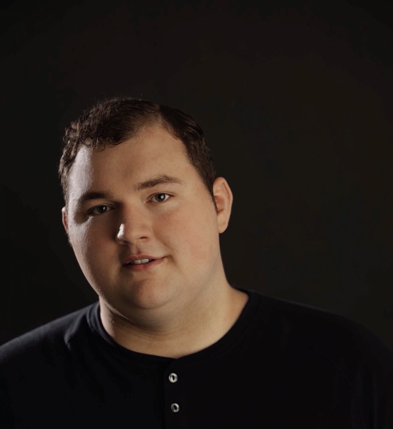 a man in a black shirt is posing for a photo