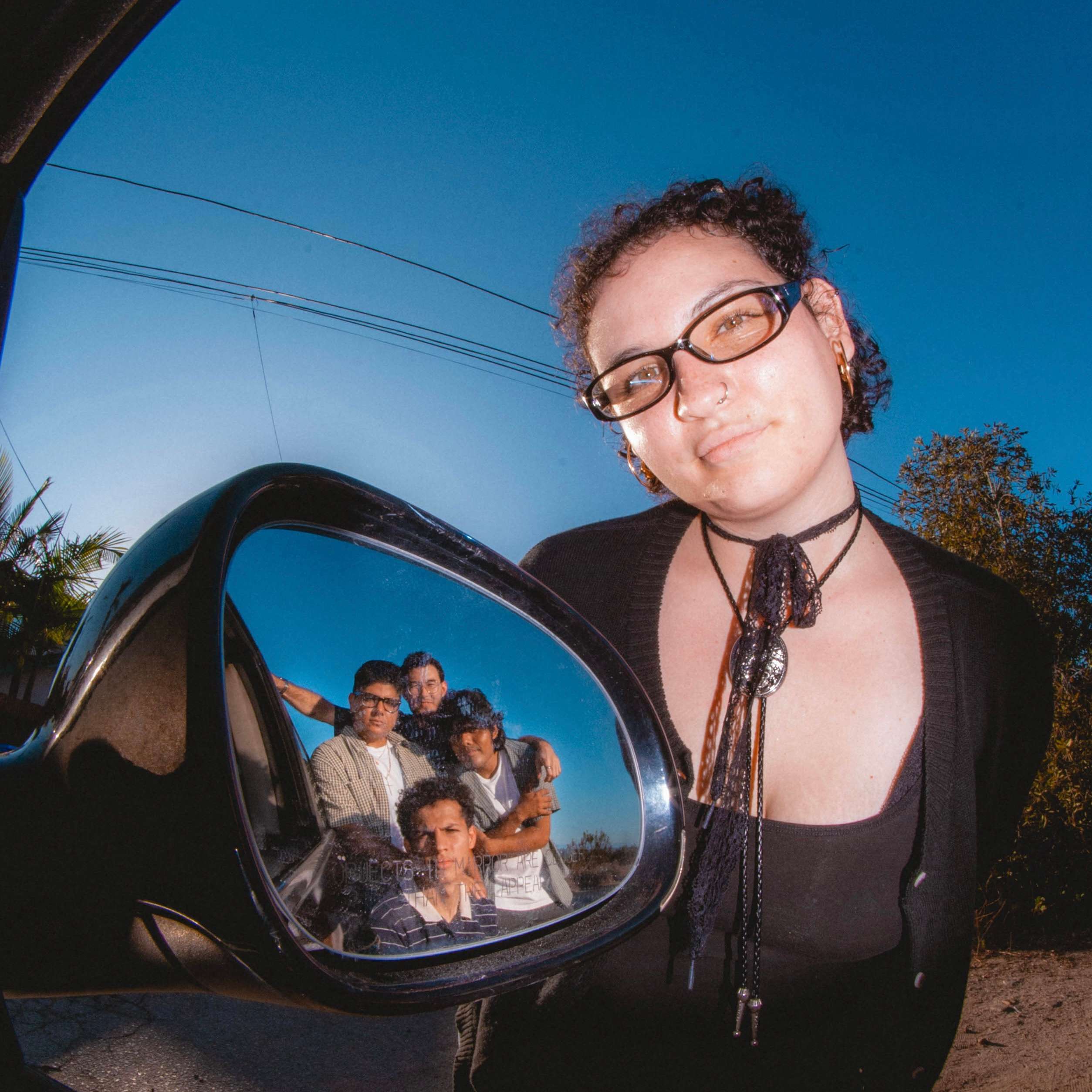 SUPERCOOL! - Rearview: a woman in glasses is standing in front of a car mirror