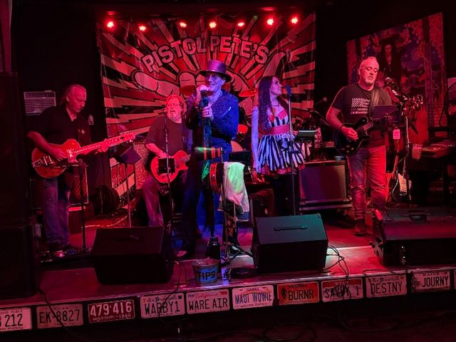 a band performs on stage in front of a sign