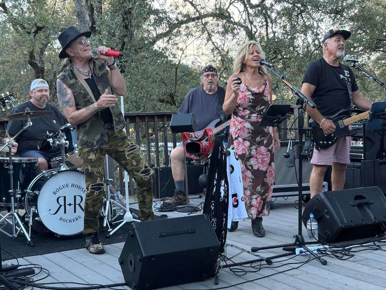 a group of people playing music on a wooden deck