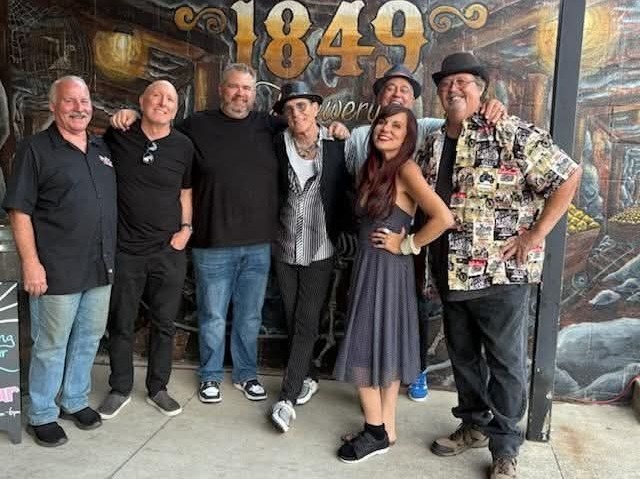 a group of people posing in front of a bar