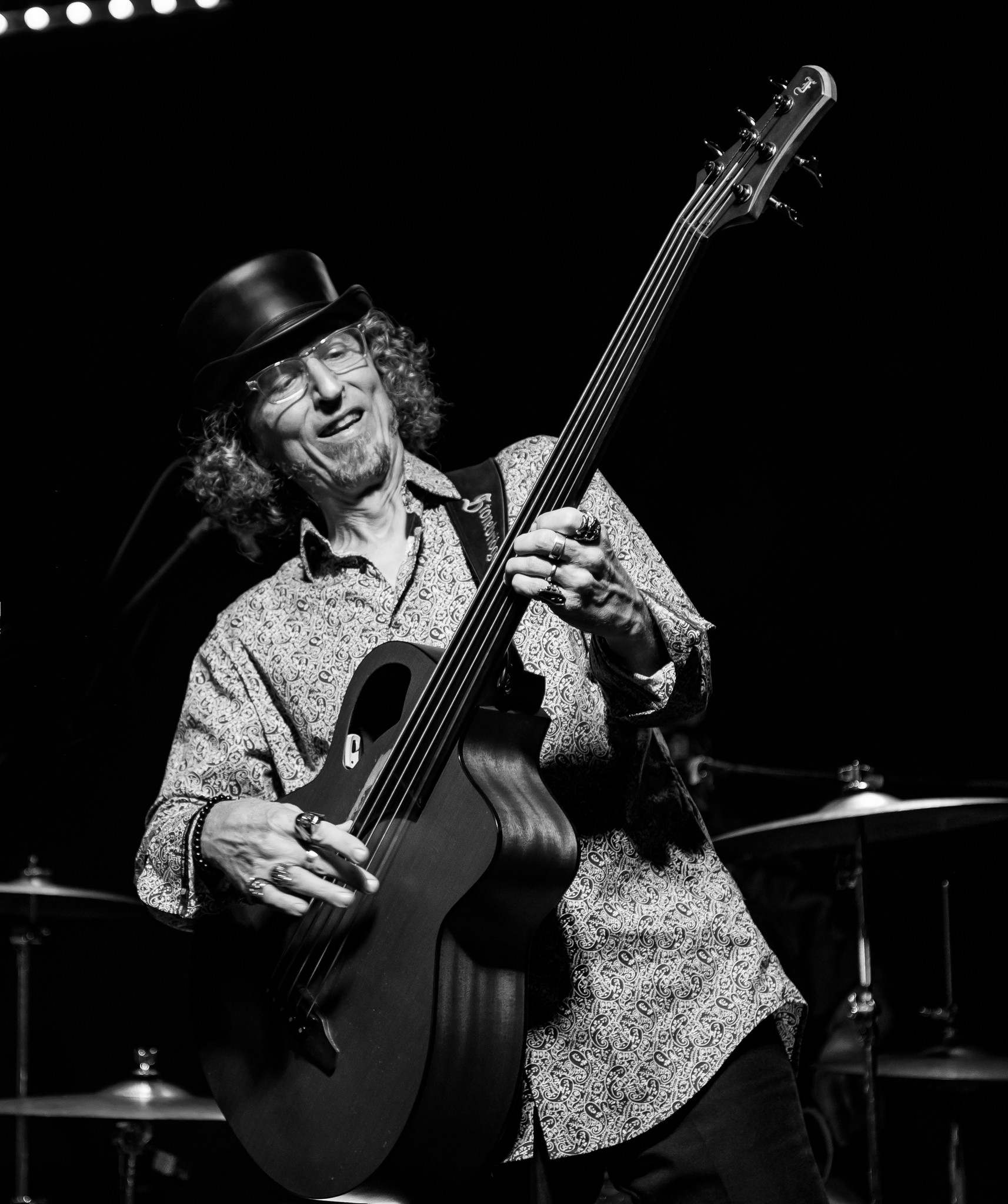 a man in a hat playing a bass guitar