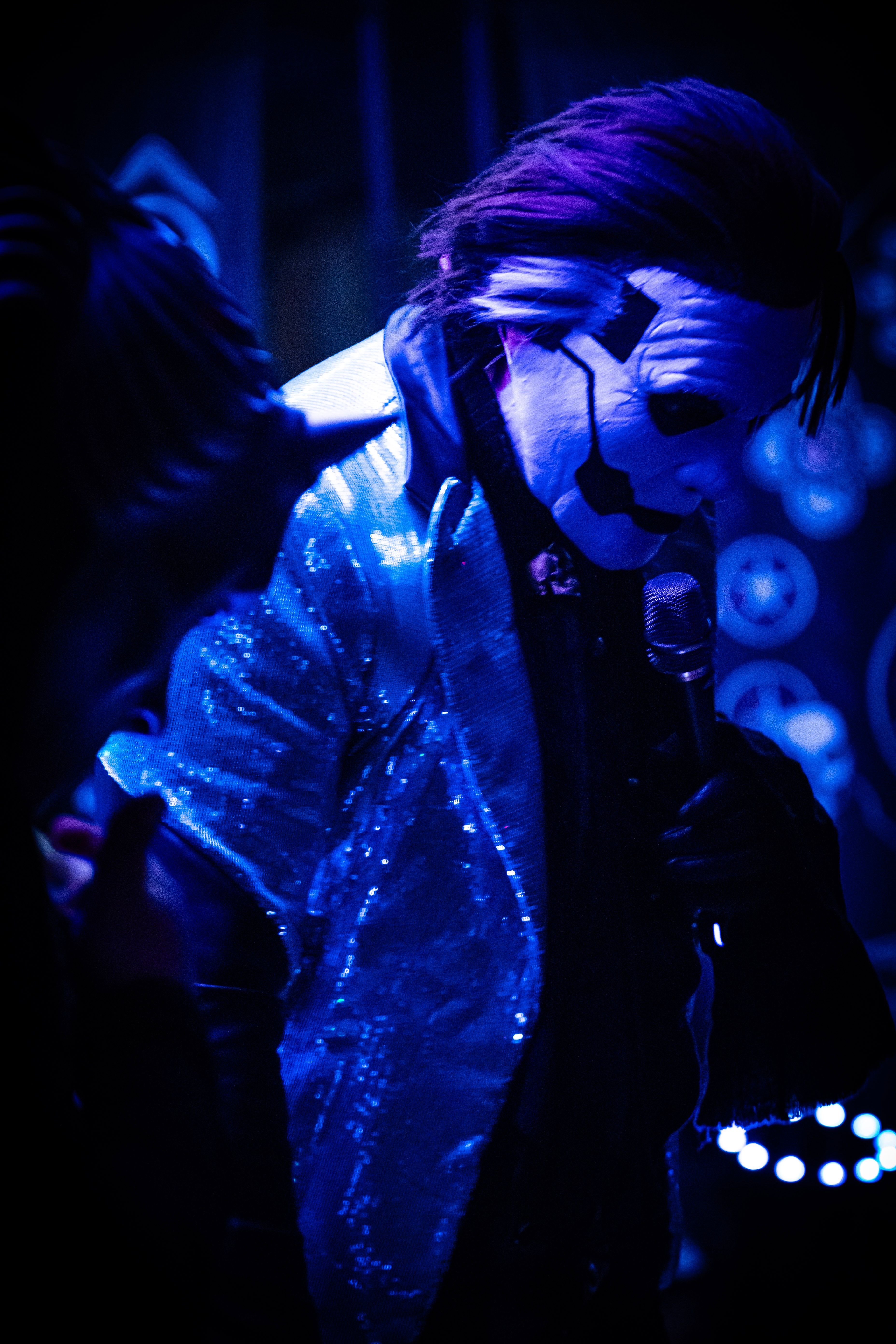 a man in a mask is holding a microphone