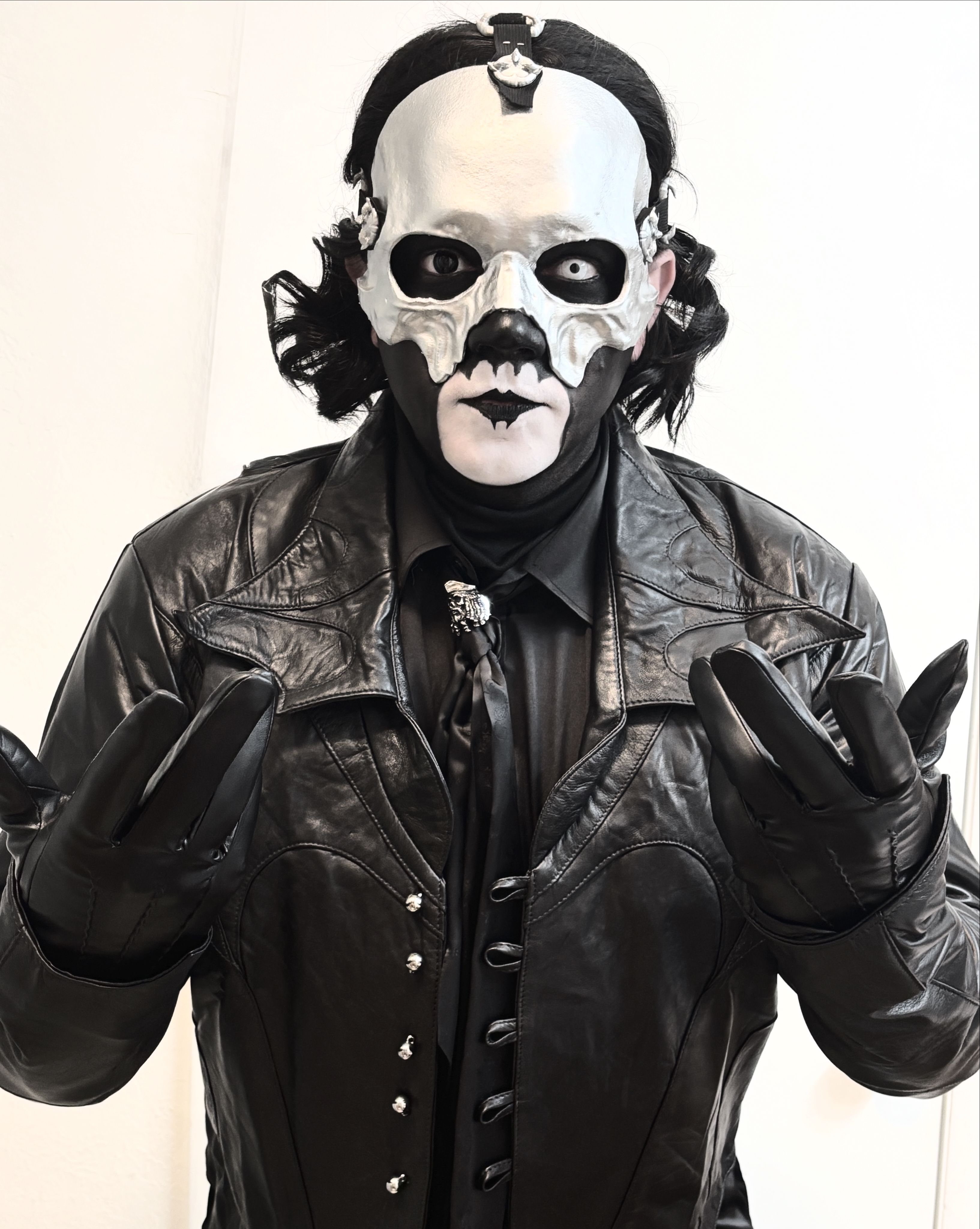 a man in a black leather jacket with a mask on his face