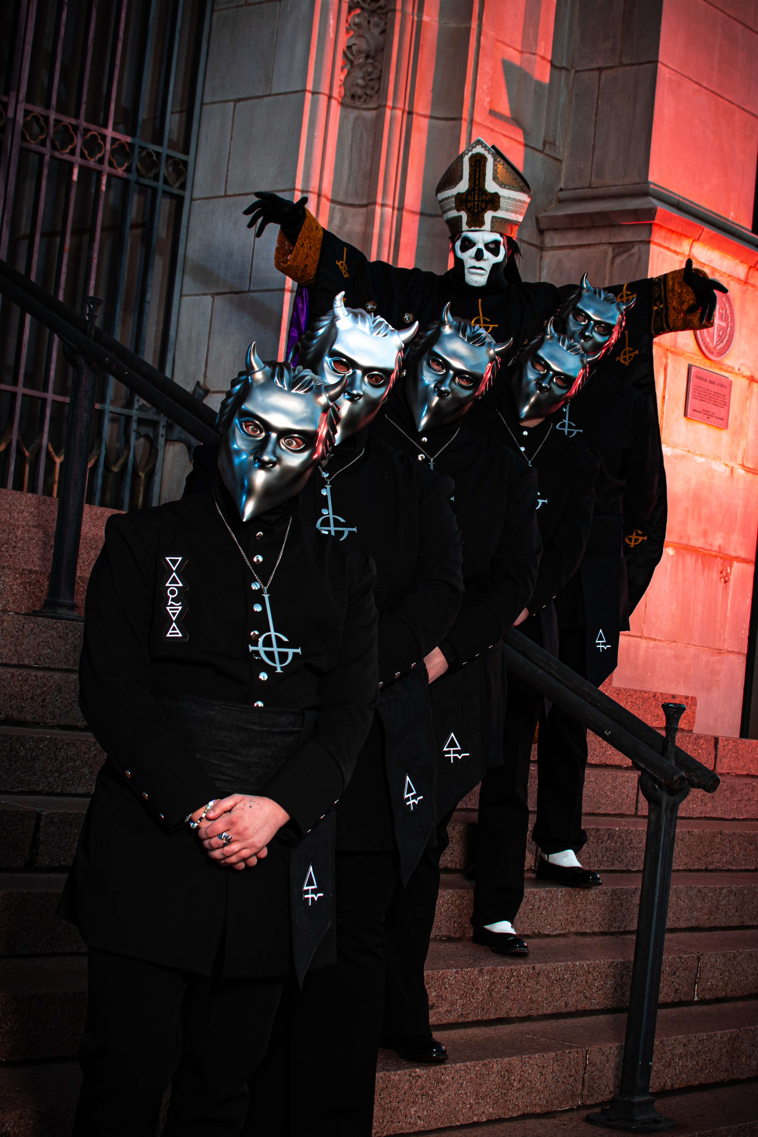 a group of men in masks standing on steps