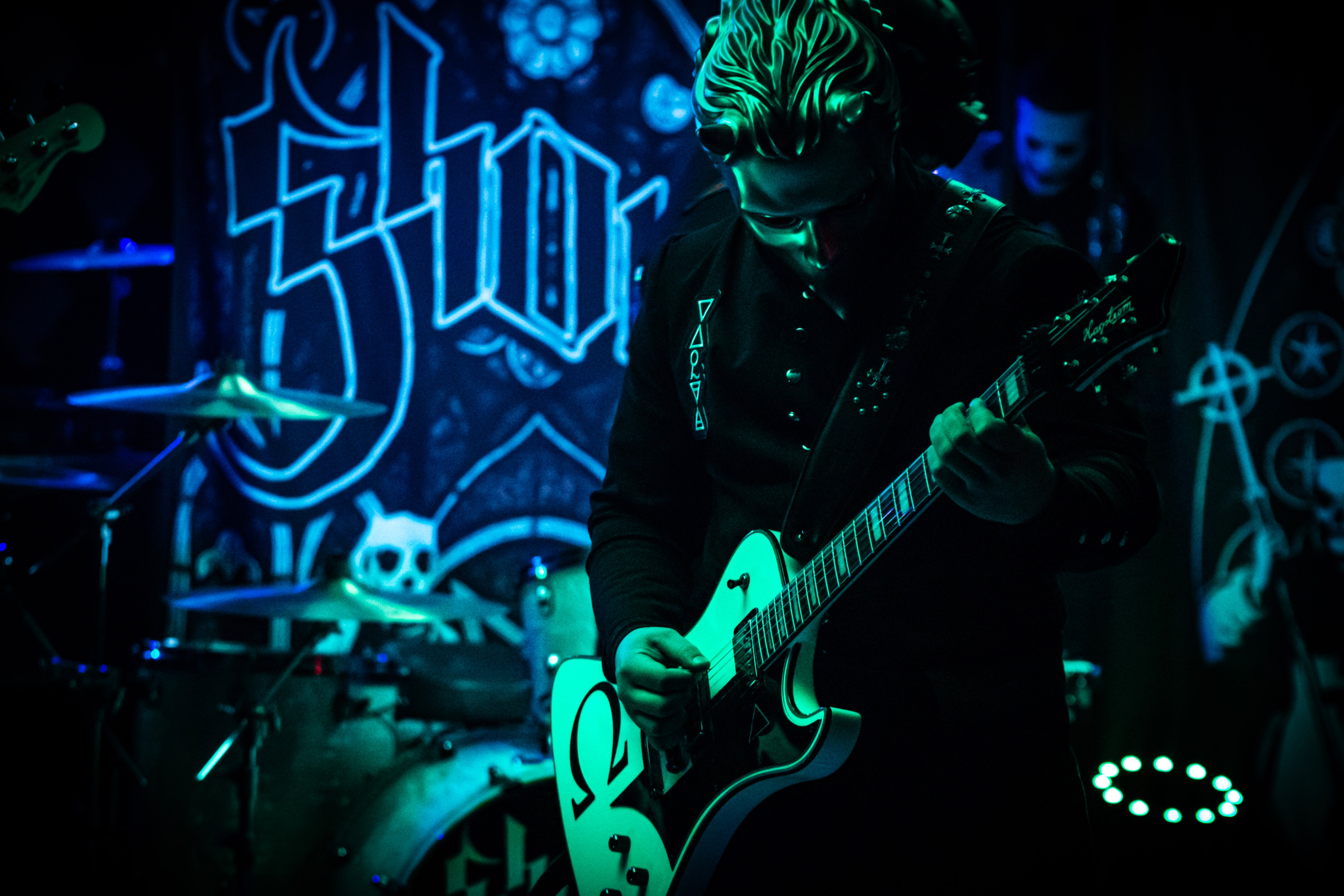 a man playing a guitar in a dark room
