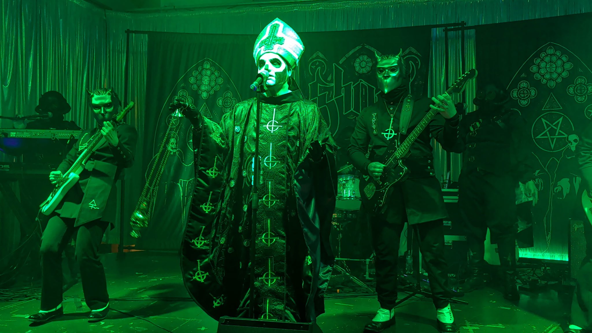a group of people dressed in green costumes on stage